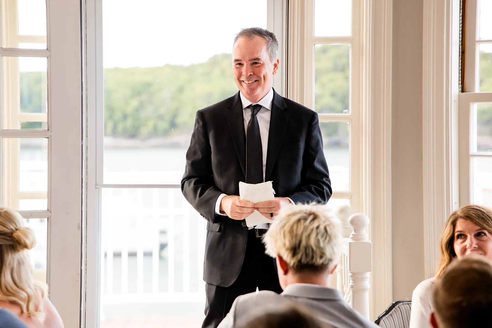 A dad smiles as he gives a toast during a wedding reception in the Porcupine Room at the Bar Harbor Inn and Spa near Acadia National Park in Maine.