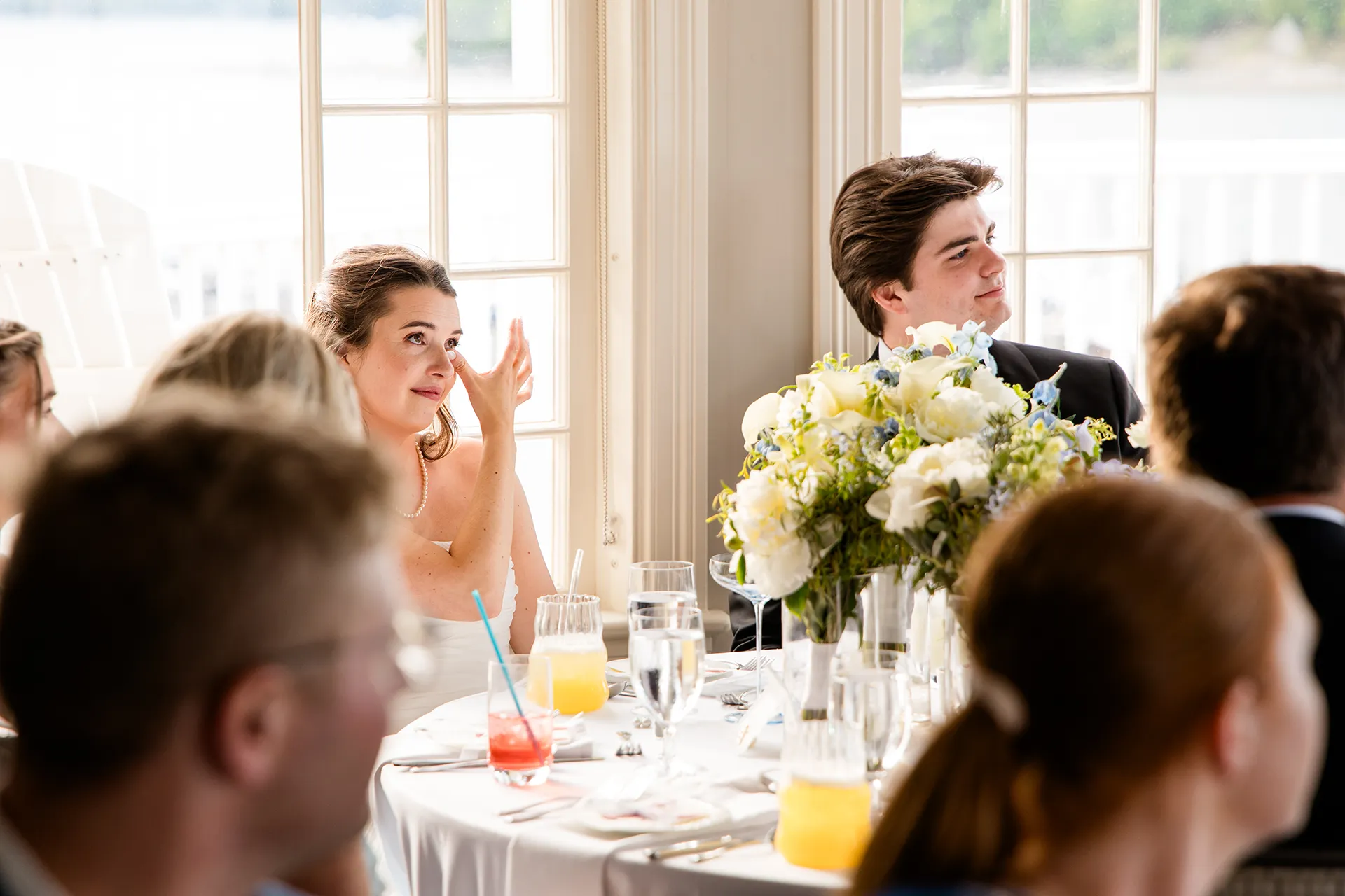 A bride wipes away a tear while she listens to a toast during a wedding reception in the Porcupine Room at the Bar Harbor Inn and Spa in Maine.