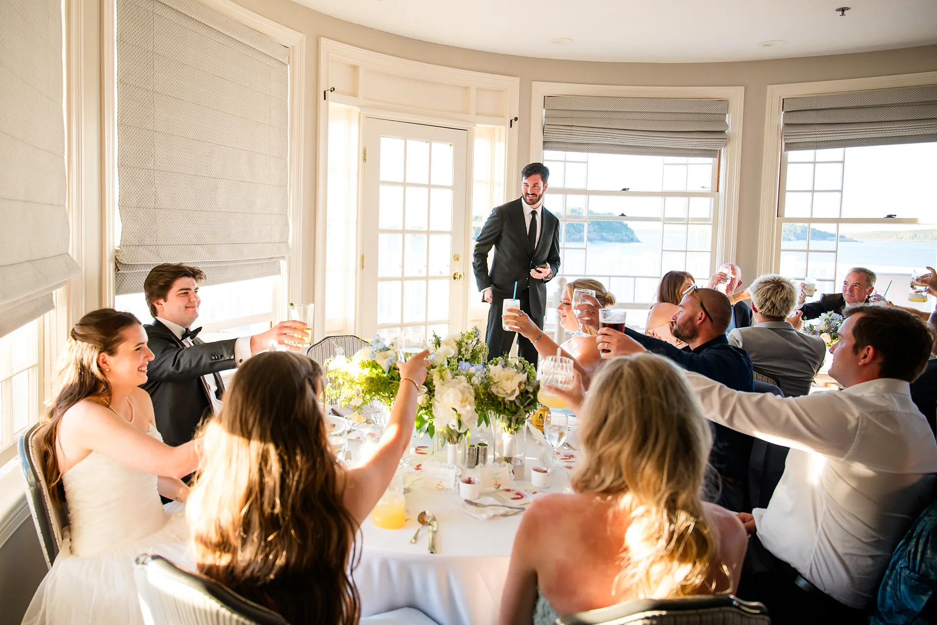 Guests raise their glasses after a toast during a wedding reception in the Porcupine Room at the Bar Harbor Inn and Spa in Maine.