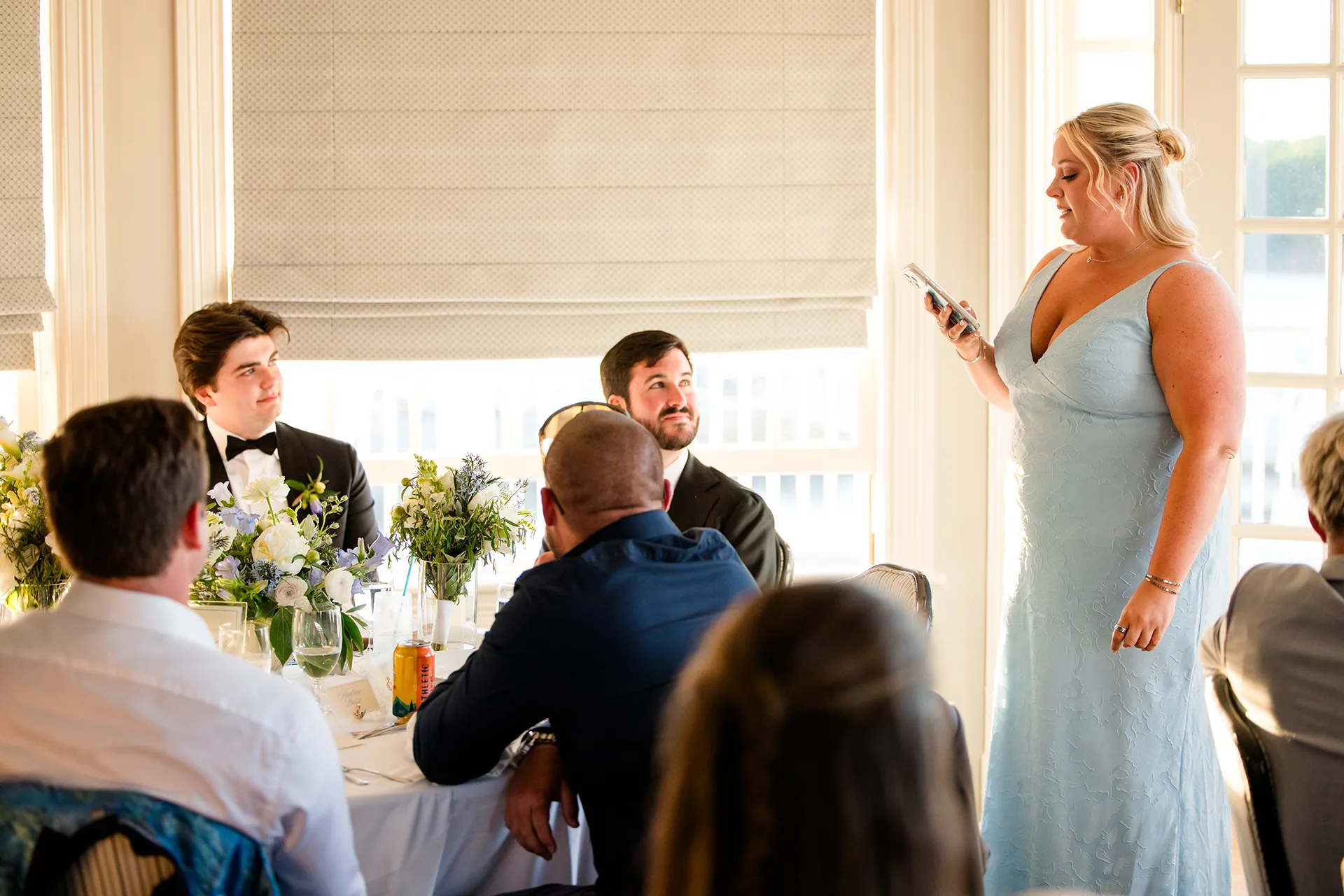 A bridesmaid reads from her phone as she give a toast during a wedding reception in the Porcupine Room at the Bar Harbor Inn and Spa in Maine.