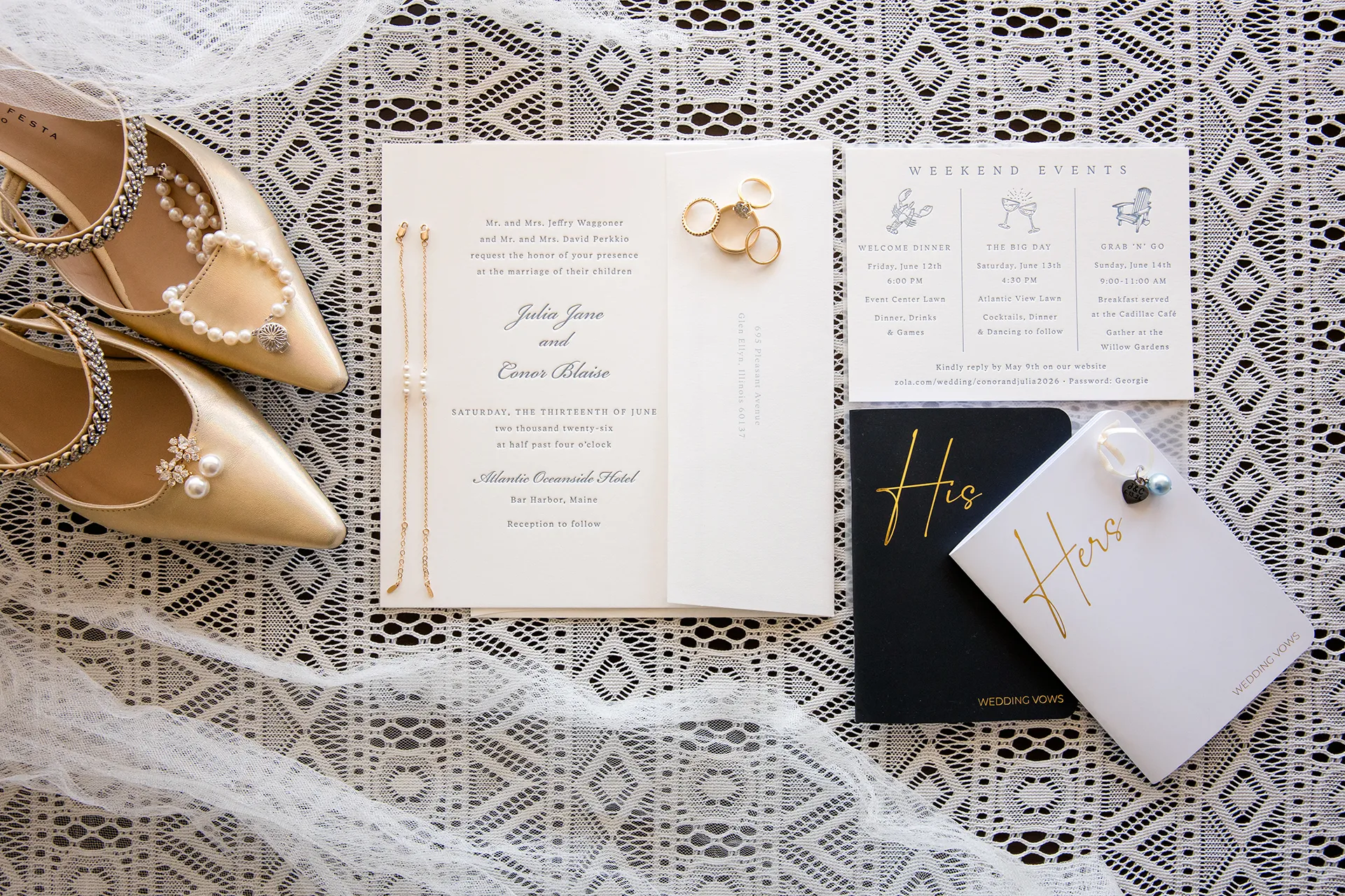 A wedding flat lay that includes wedding invitations, rings, vow books, shoes, and jewelry at the Atlantic Oceanside and Event Center in Bar Harbor, Maine.