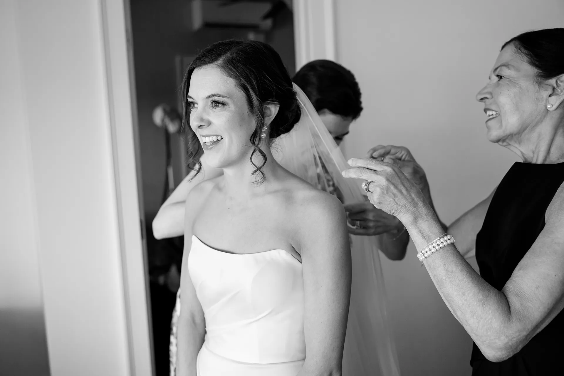 A bride smiles as her mom puts on her veil for her wedding at the Atlantic Oceanside and Event Center in Bar Harbor, Maine.