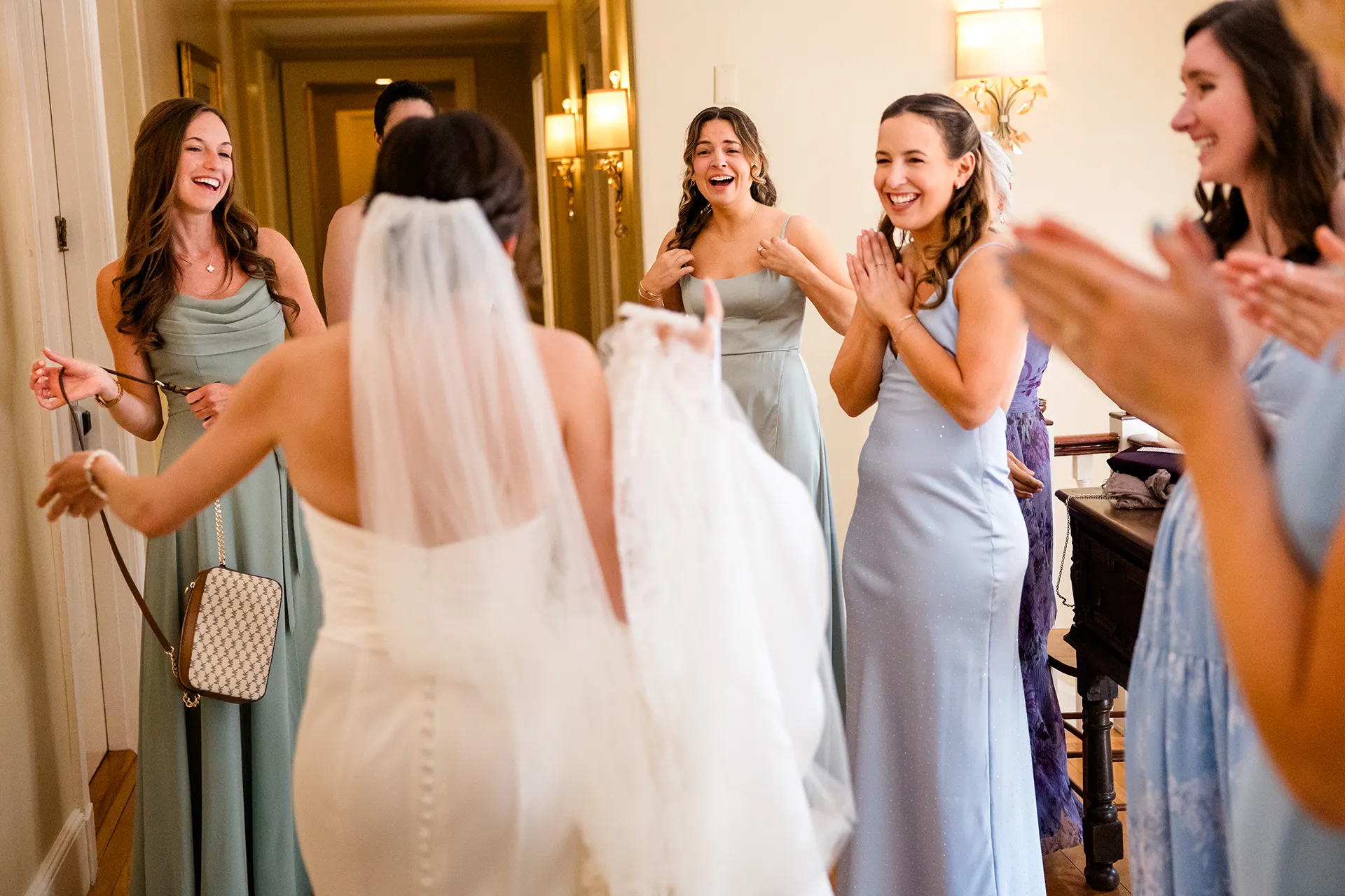 Bridesmaids cheer as they see the bride for the first time at the Atlantic Oceanside and Event Center in Bar Harbor, Maine.