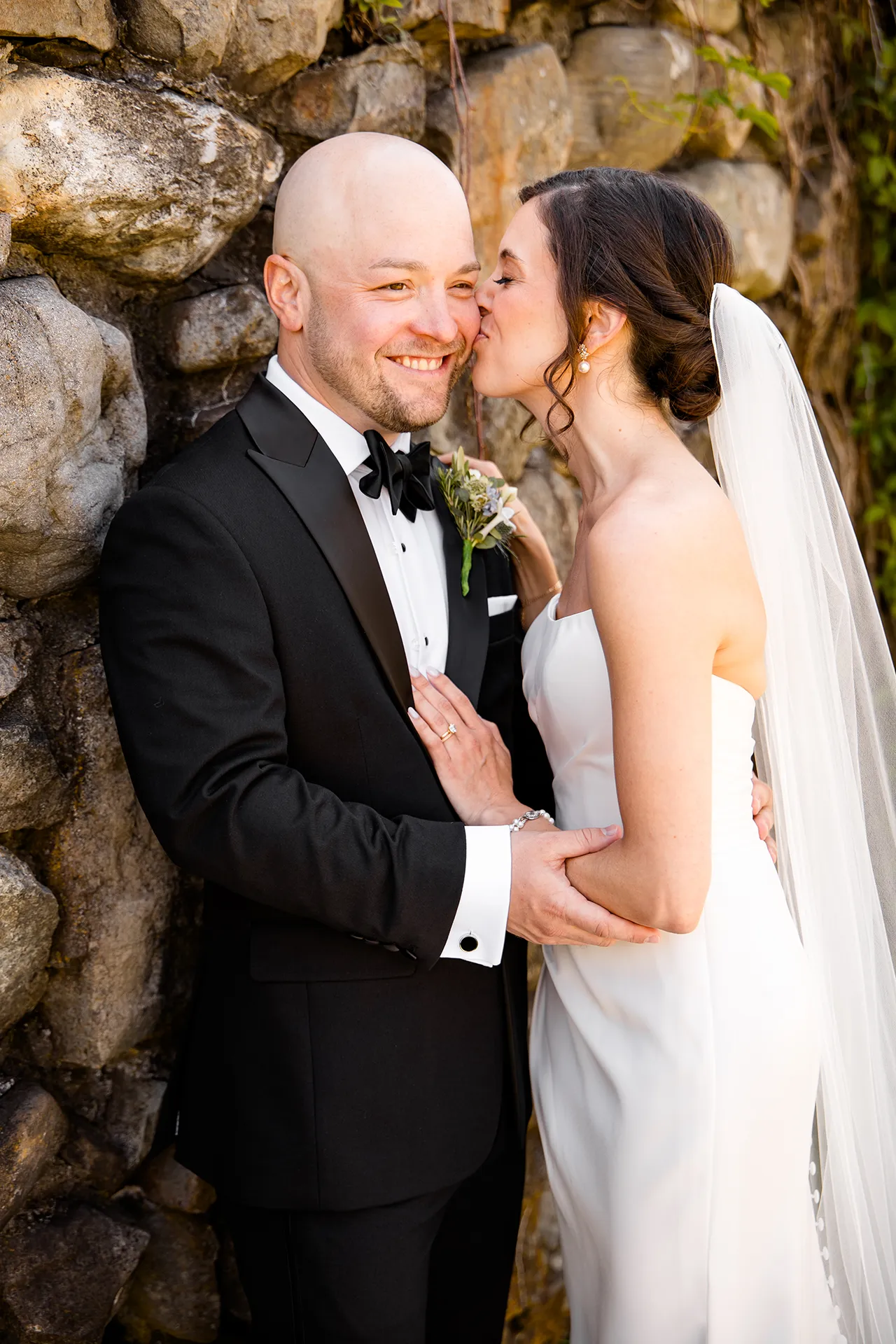 A bride kissed a groom on the cheek during wedding portraits at the Atlantic Oceanside Hotel & Event Center in Bar Harbor, Maine.