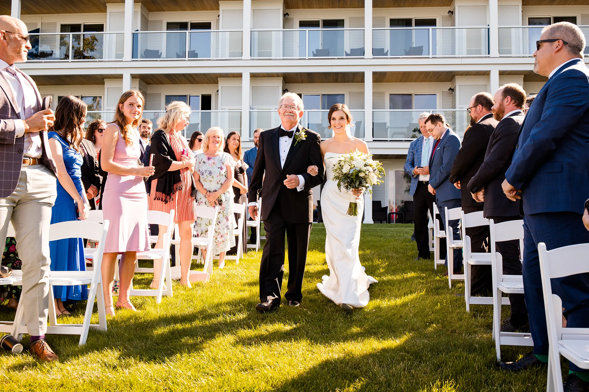 A bride and her dad walk down the aisle during a wedding ceremony at the Atlantic Oceanside Hotel & Event Center in Bar Harbor, Maine.