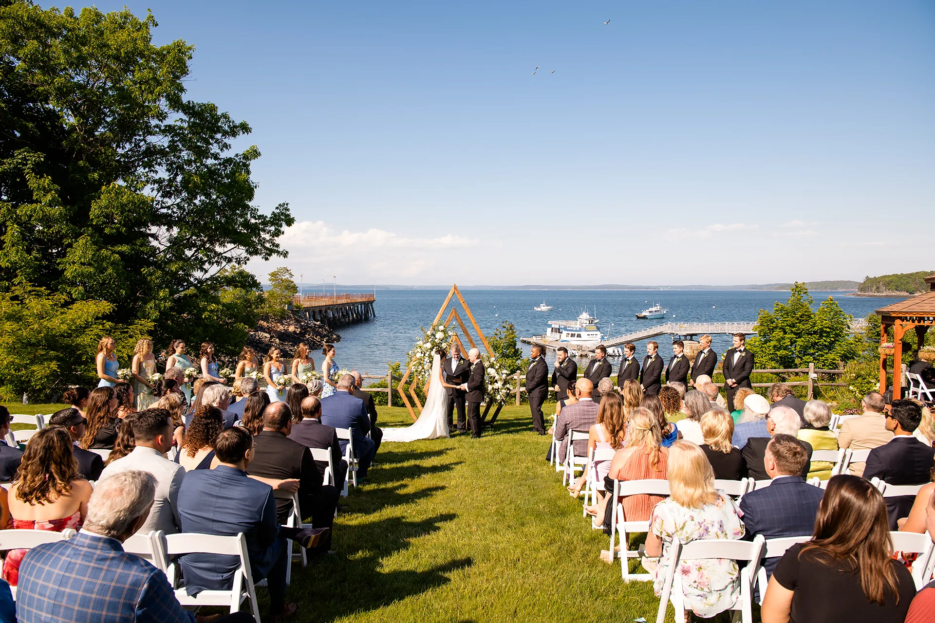 A bride and groom stand at the head of the aisle during a wedding ceremony at the Atlantic Oceanside Hotel & Event Center in Bar Harbor, Maine.