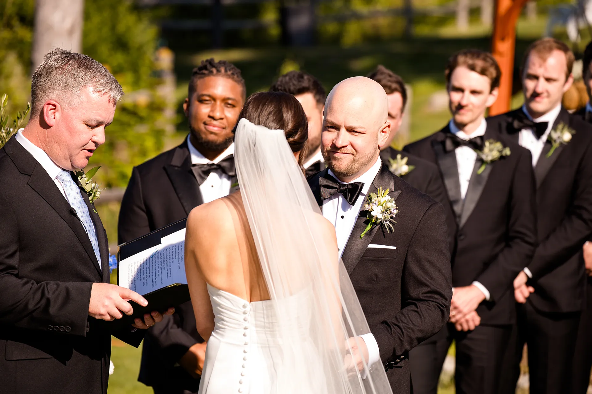 A groom smiles at a bride during a wedding ceremony at the Atlantic Oceanside Hotel & Event Center in Bar Harbor, Maine.
