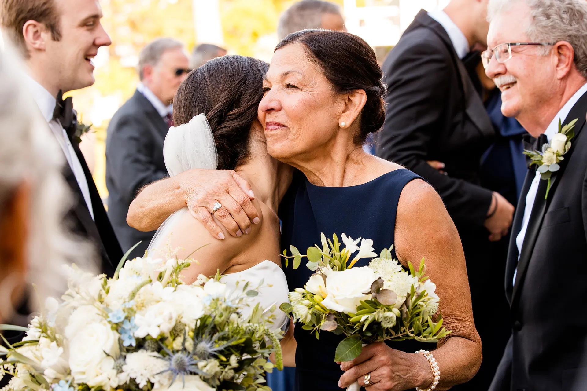 A mom hugs a bride after a wedding ceremony at the Atlantic Oceanside Hotel & Event Center in Bar Harbor, Maine.