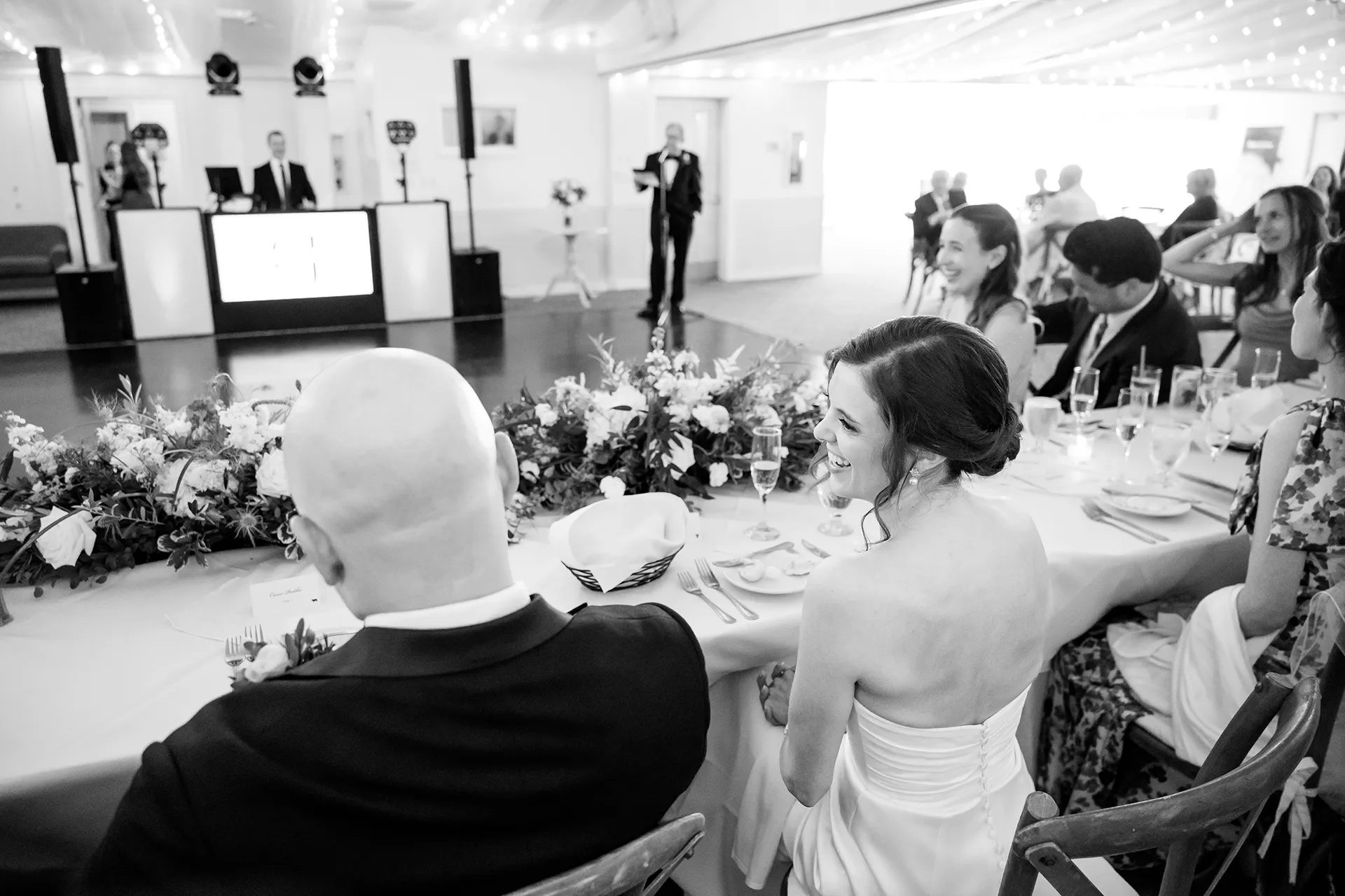 A bride laughs as she listens to a toast during a wedding reception at the Atlantic Oceanside Hotel & Event Center in Bar Harbor, Maine.