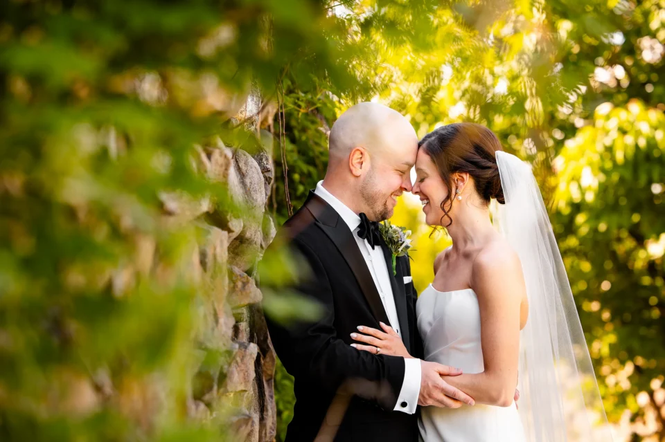 A bride and groom smile as they rest their foreheads together during wedding portraits at the Atlantic Oceanside Hotel & Event Center in Bar Harbor, Maine.