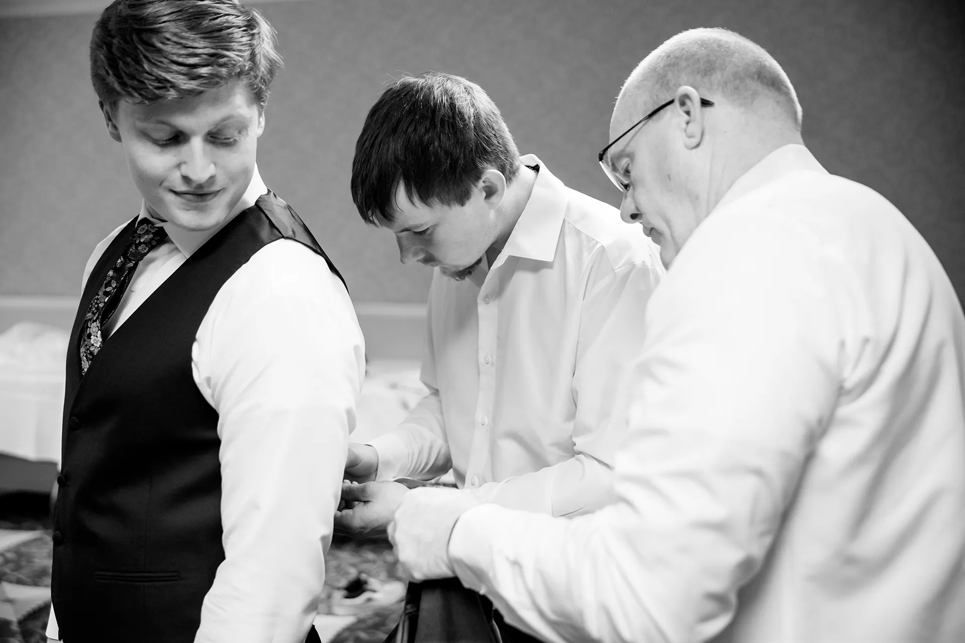 A dad and groomsmen help a groom get ready for a wedding at the Hilton Garden Inn in Bangor, Maine.