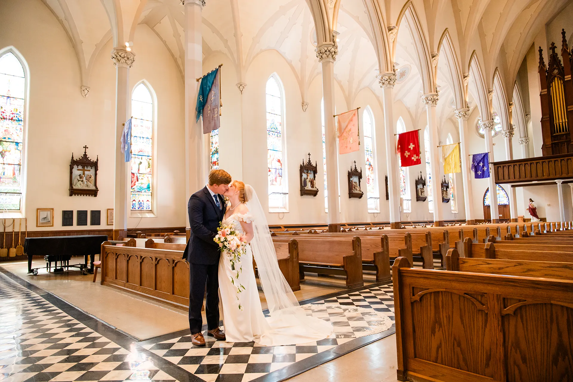 A bride and groom kiss during wedding portraits at Saint John's Catholic Church in Bangor, Maine.