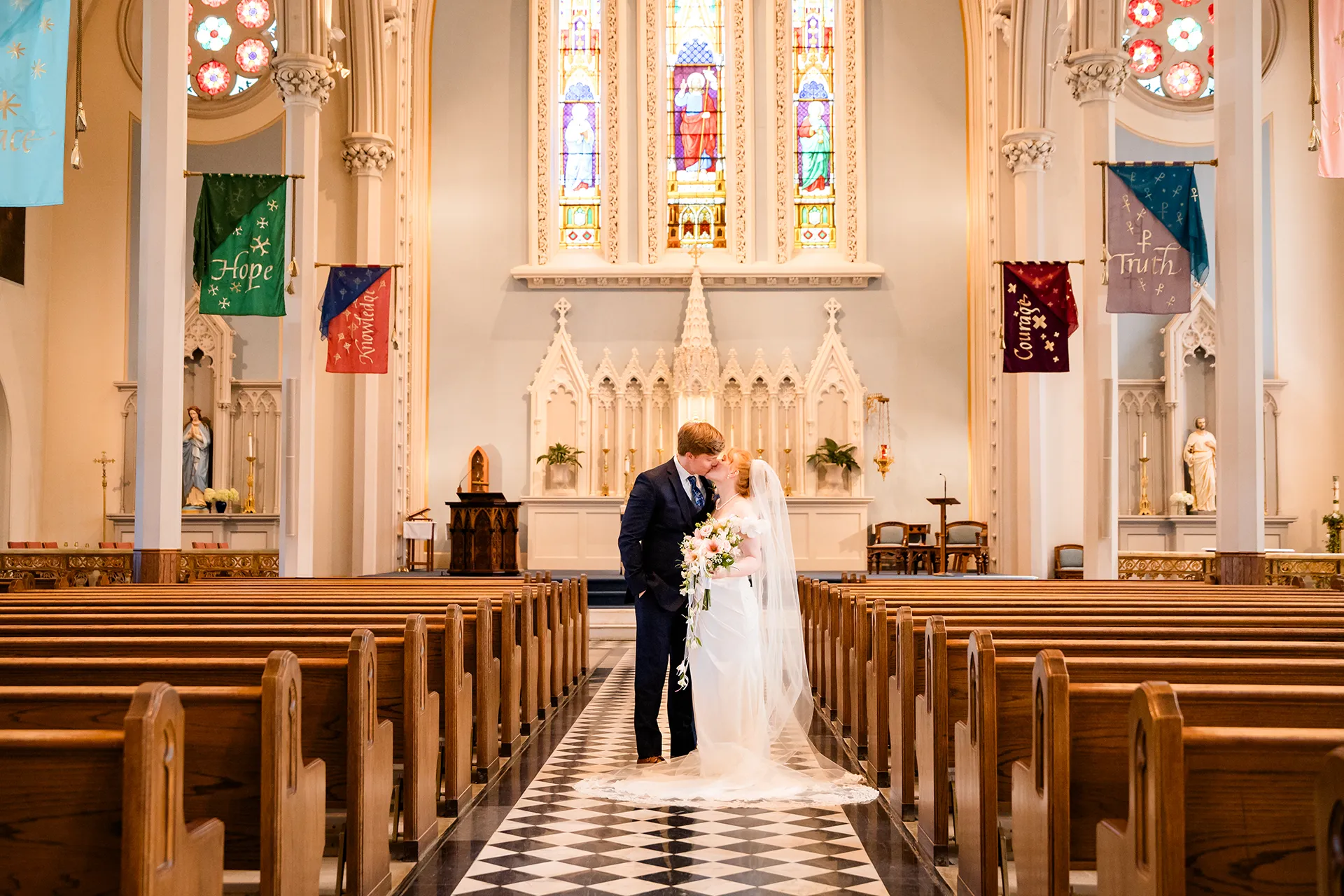 A newly married kiss during wedding portraits at Saint John's Catholic Church in Bangor, Maine.
