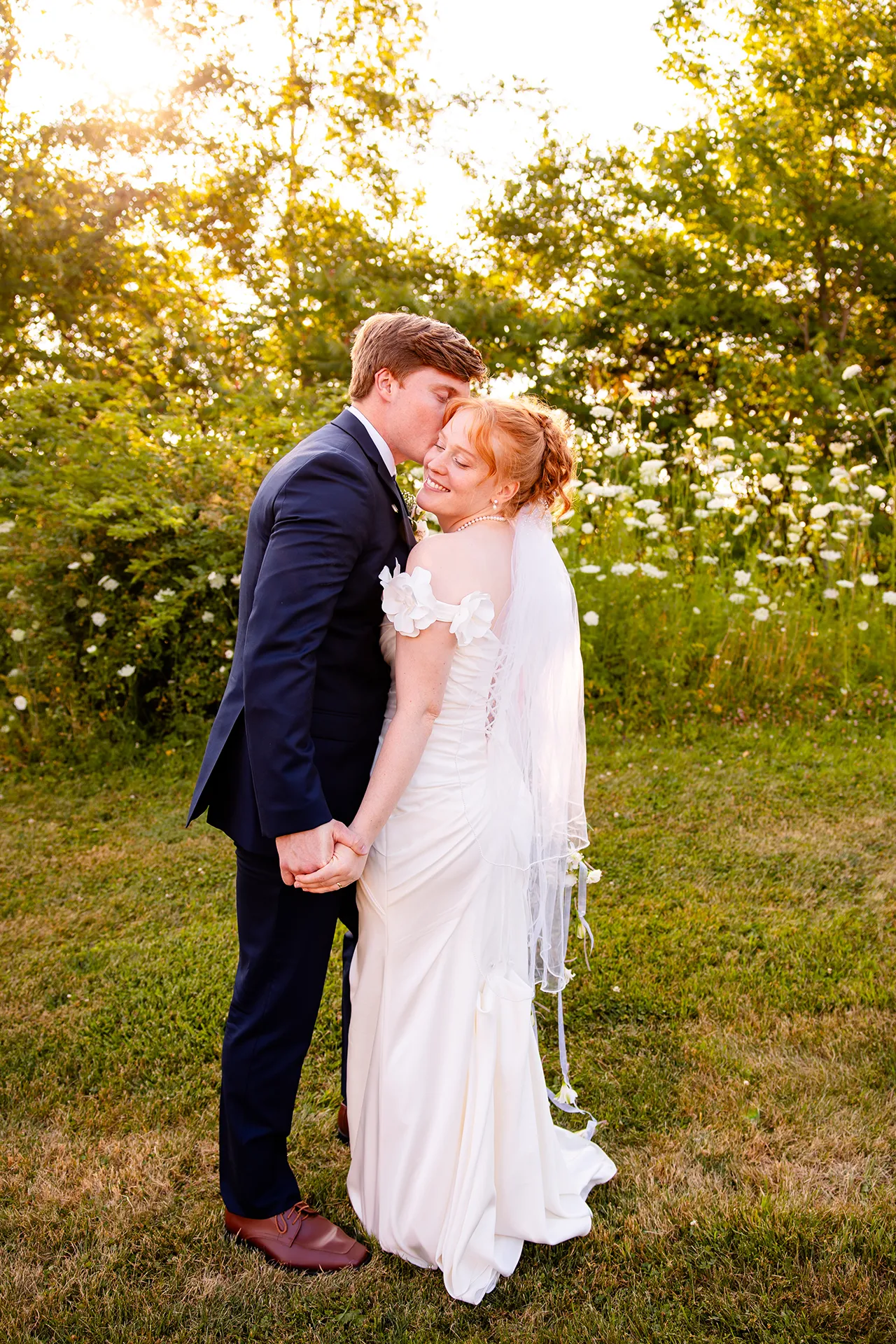 A groom kisses a bride on the cheek during wedding portraits at the Hilton Garden Inn in Bangor, Maine.