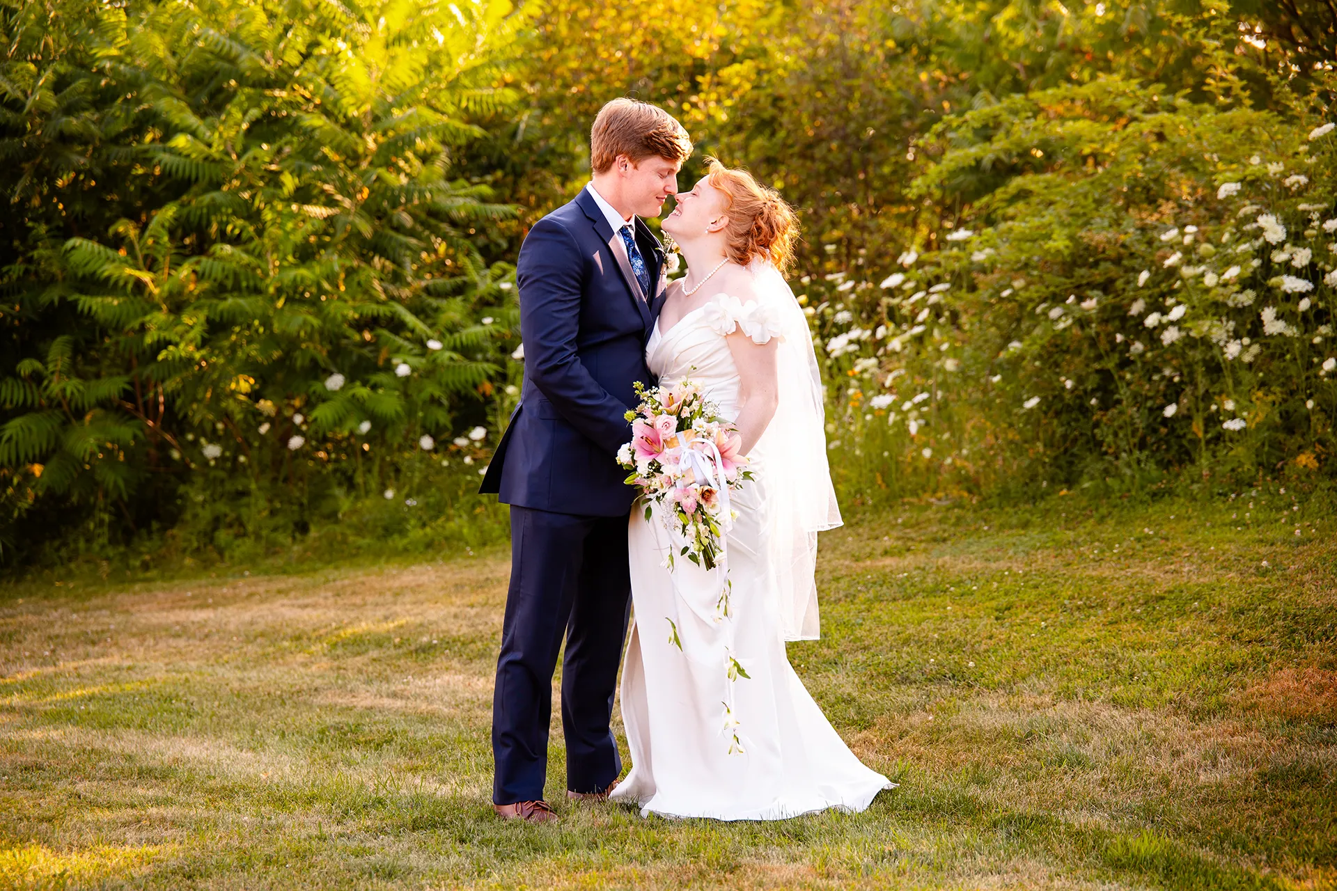 A newly married couple smile at each other while rubbing noses during wedding portraits at the Hilton Garden Inn in Bangor, Maine.