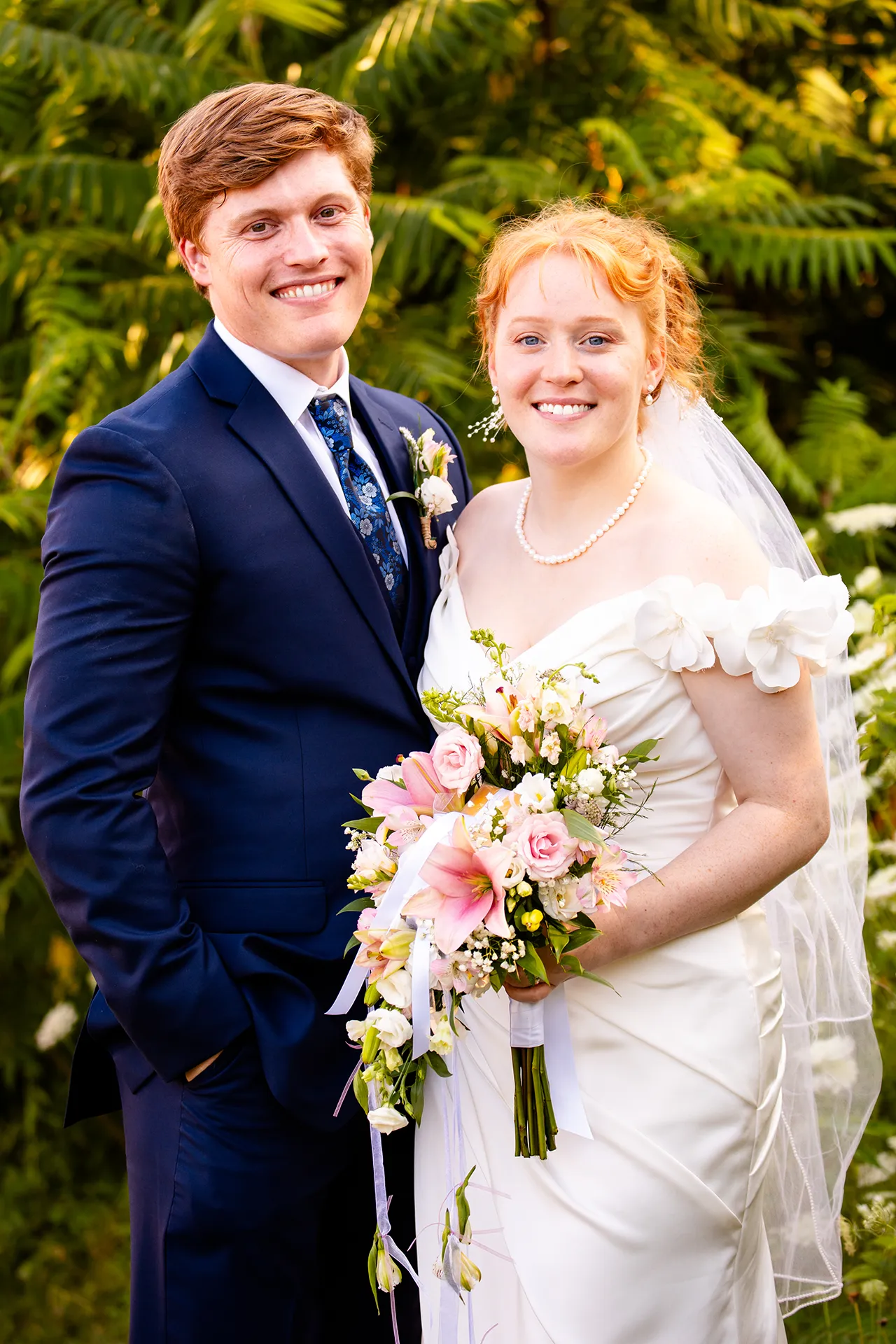 A bride and groom smile and pose during wedding portraits at the Hilton Garden Inn in Bangor, Maine.