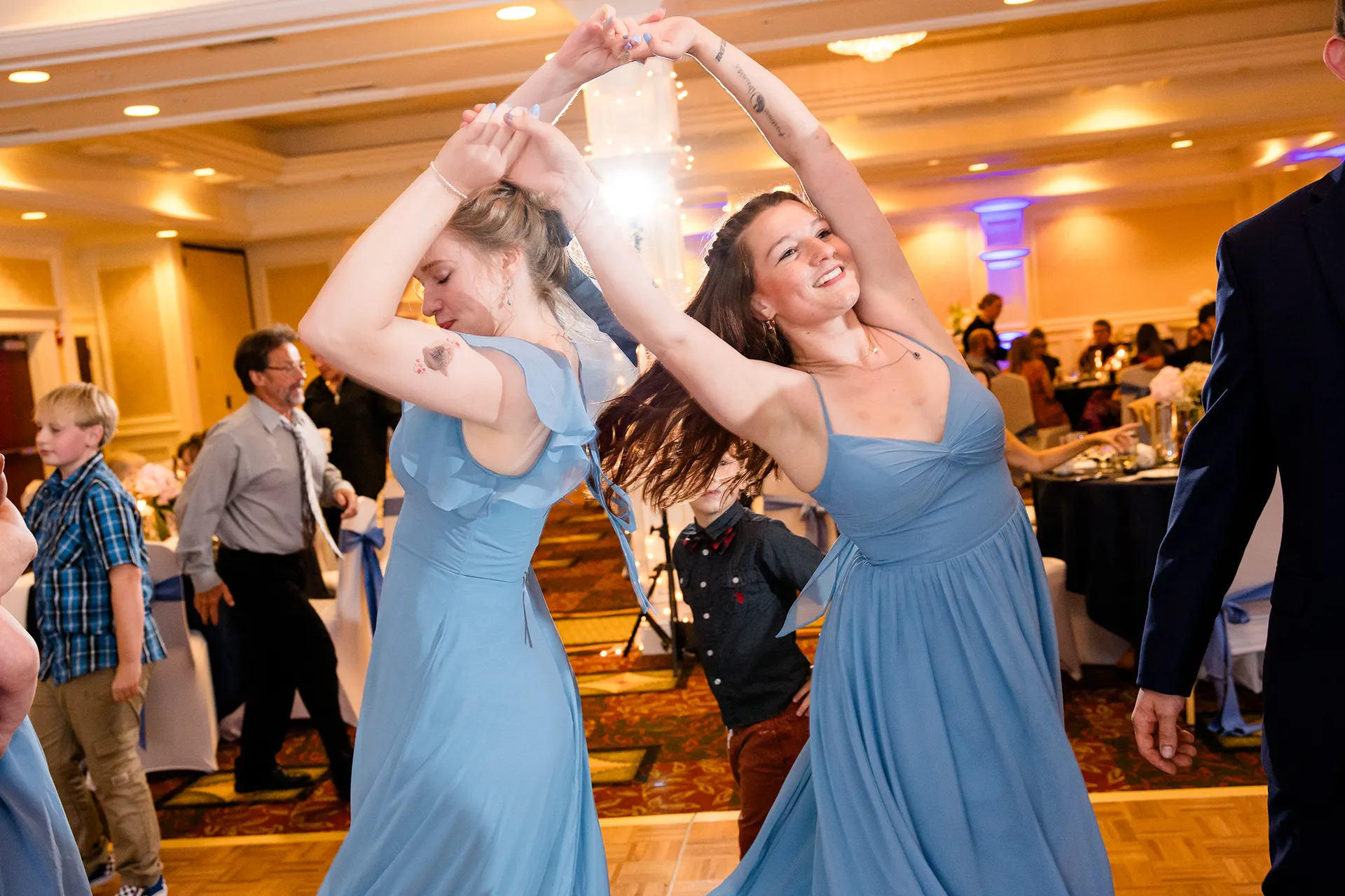 Bridesmaids wearing blue dance together during a wedding reception at Hilton Garden Inn in Bangor, Maine.