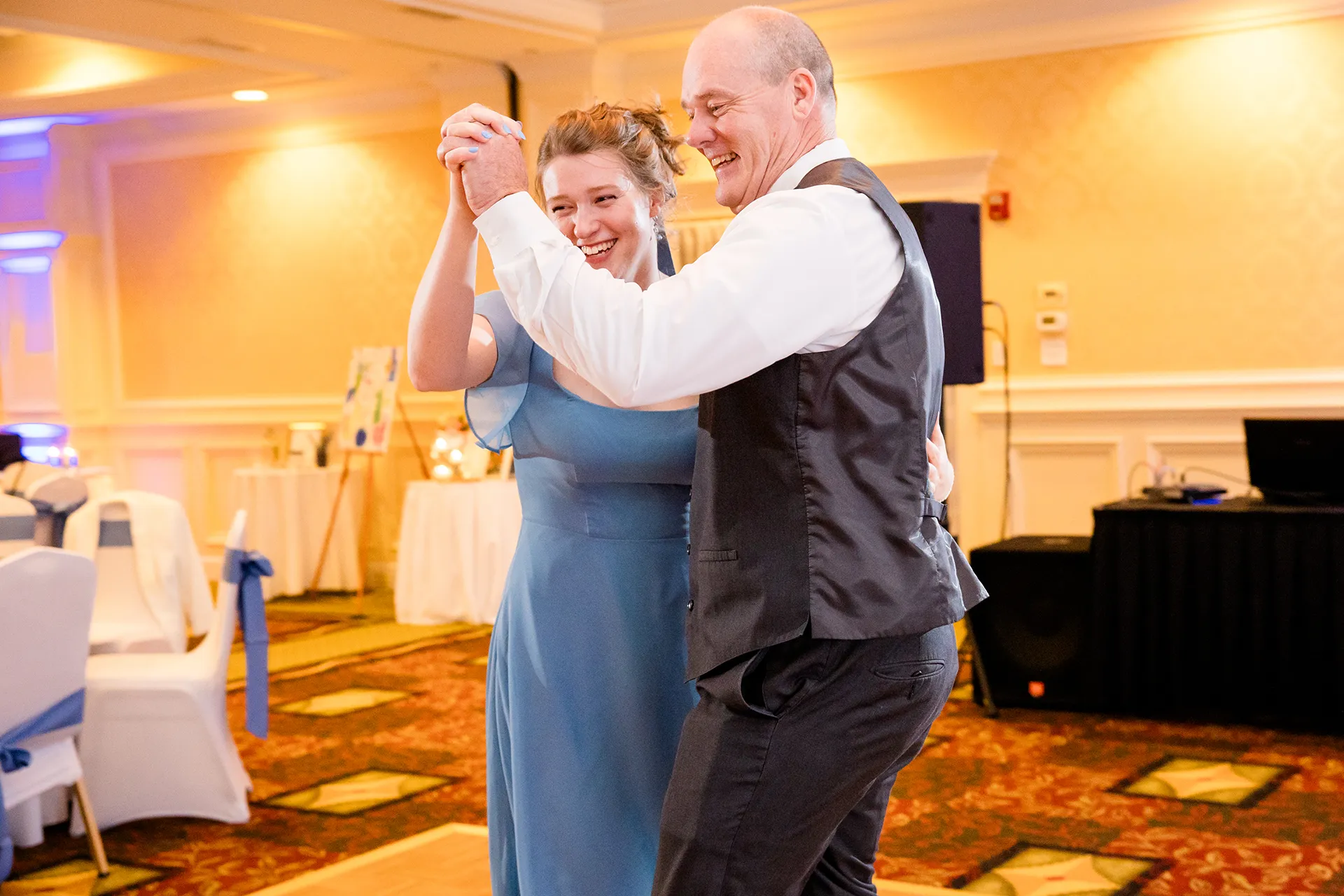 A bridesmaid and her dad laugh as they dance during a wedding reception at Hilton Garden Inn in Bangor, Maine.