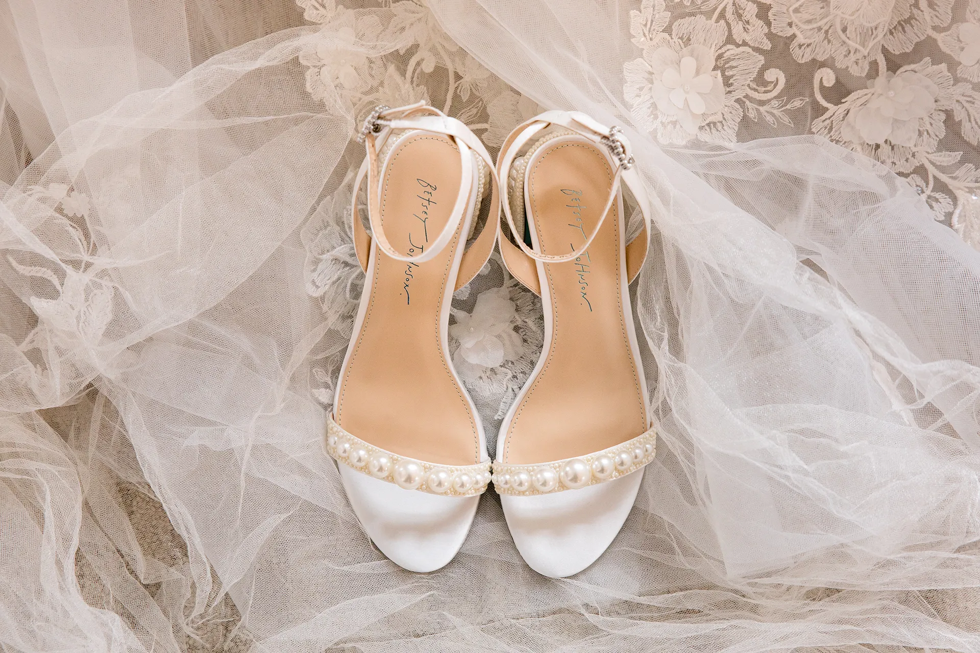 maine wedding photography bethany mike 09 A closeup of a pair of white heels with pearls for a wedding at the York Harbor Reading Room in Maine.