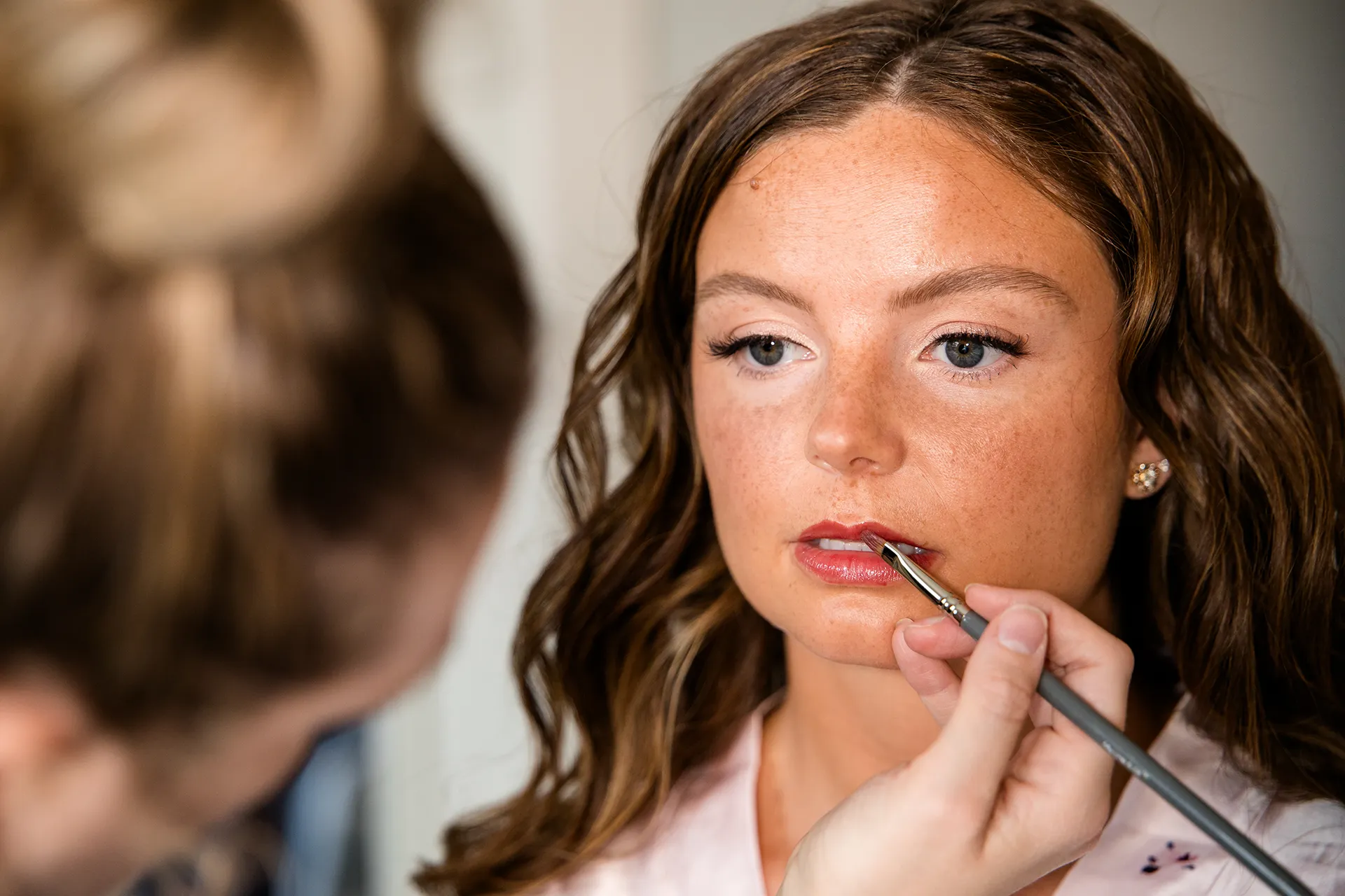 maine wedding photography bethany mike 13 A bride has her lip stick put on as she gets ready for a wedding at the York Harbor Reading Room in Maine.