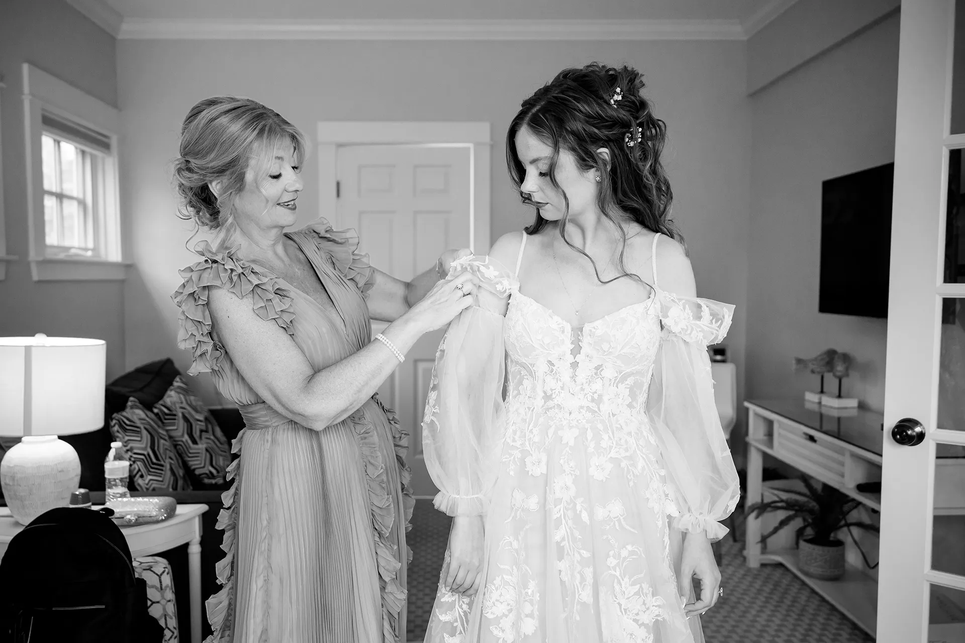 maine wedding photography bethany mike 15 A mom helps a bride put on her dress as she gets ready for a wedding at the York Harbor Reading Room in Maine.