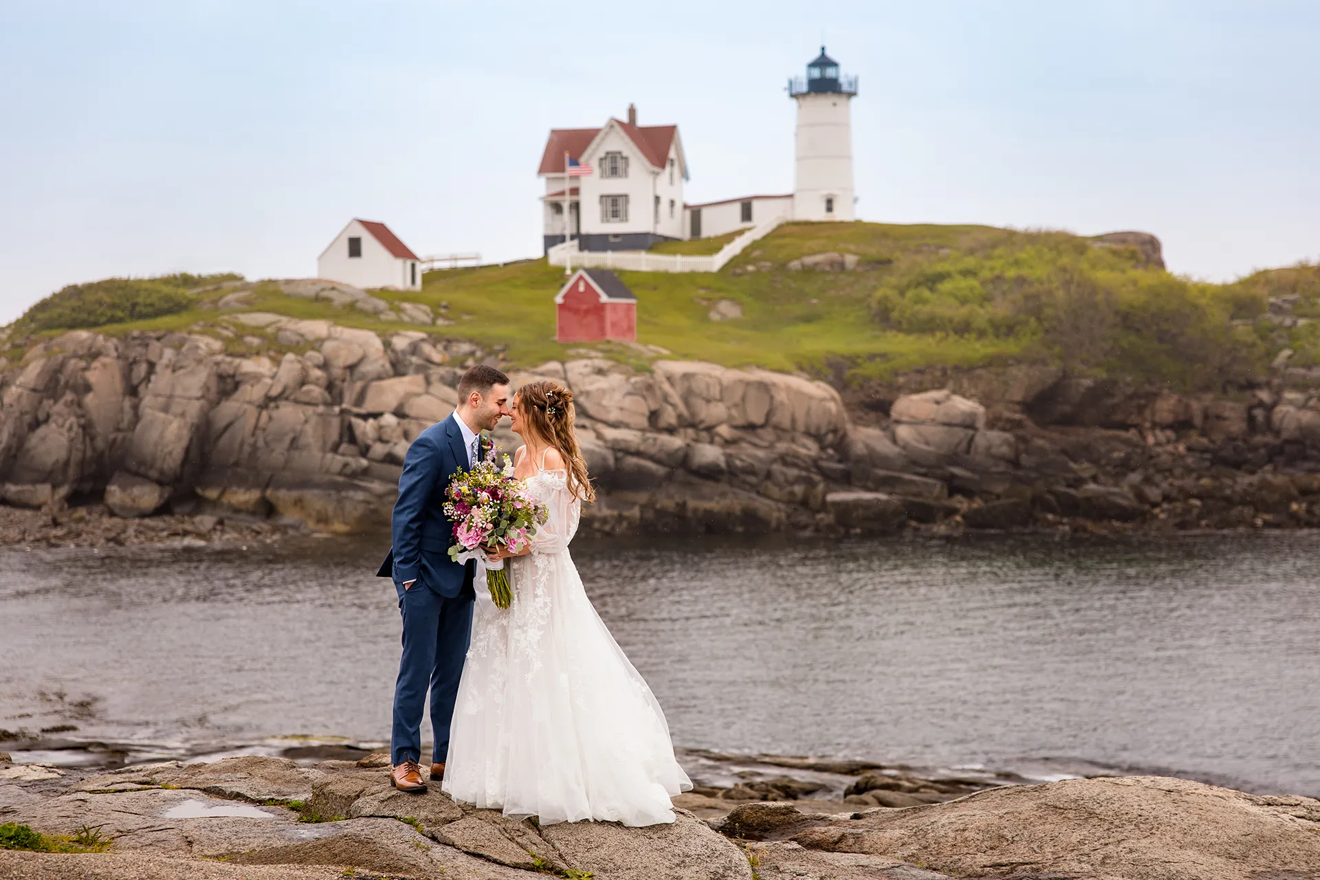 maine wedding photography bethany mike 19 A bride and groom rub noses and smile during their wedding portraits at Nubble Lighthouse in York, Maine.