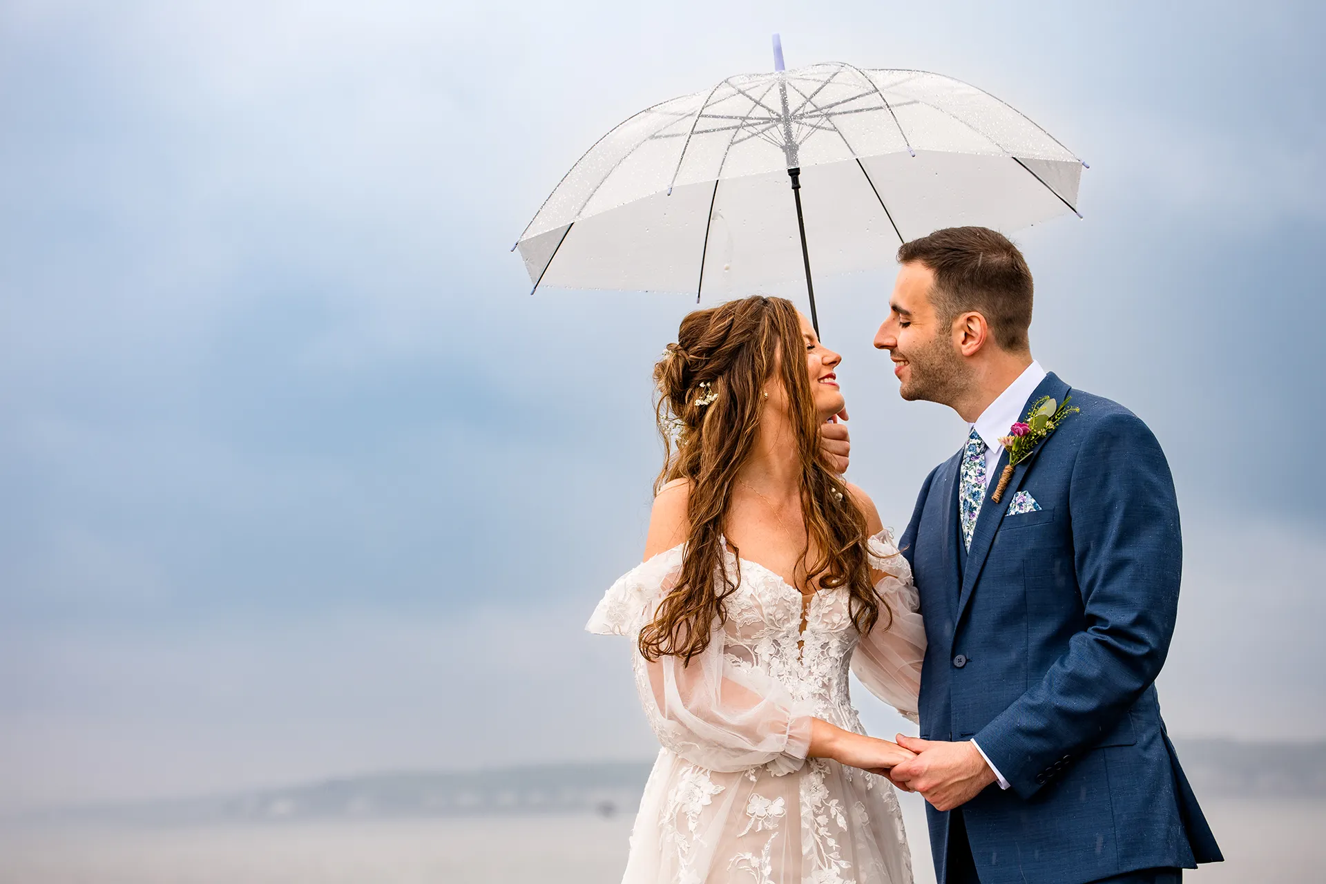 maine wedding photography bethany mike 25 A bride and groom smile at each other under an umbrella during their wedding portraits at Nubble Lighthouse in York, Maine.