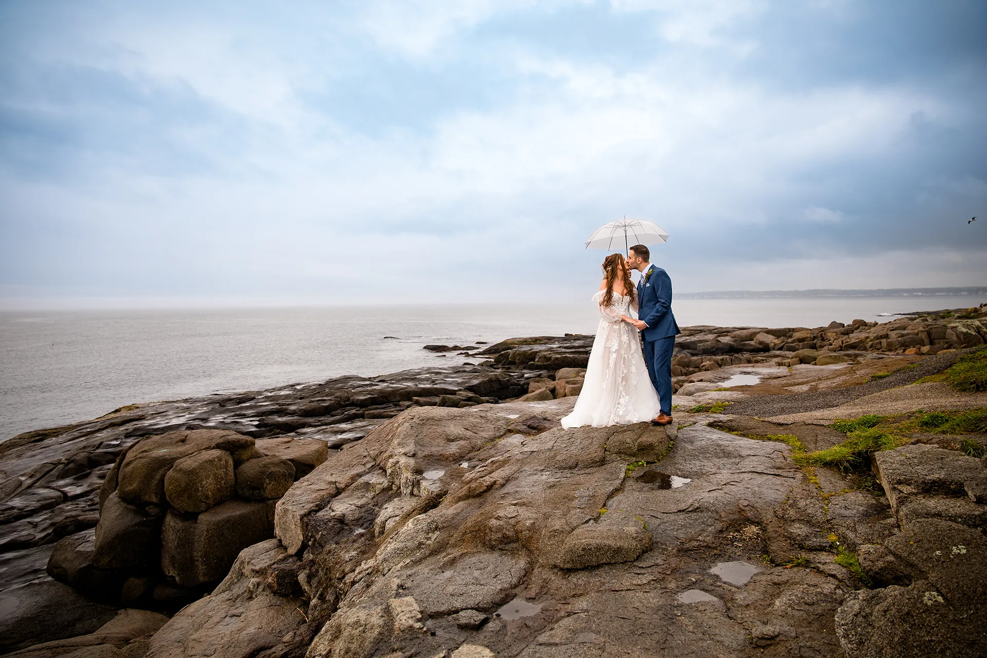 maine wedding photography bethany mike 26copy A newly married couple kiss under an umbrella during their wedding portraits at Nubble Lighthouse in York, Maine.