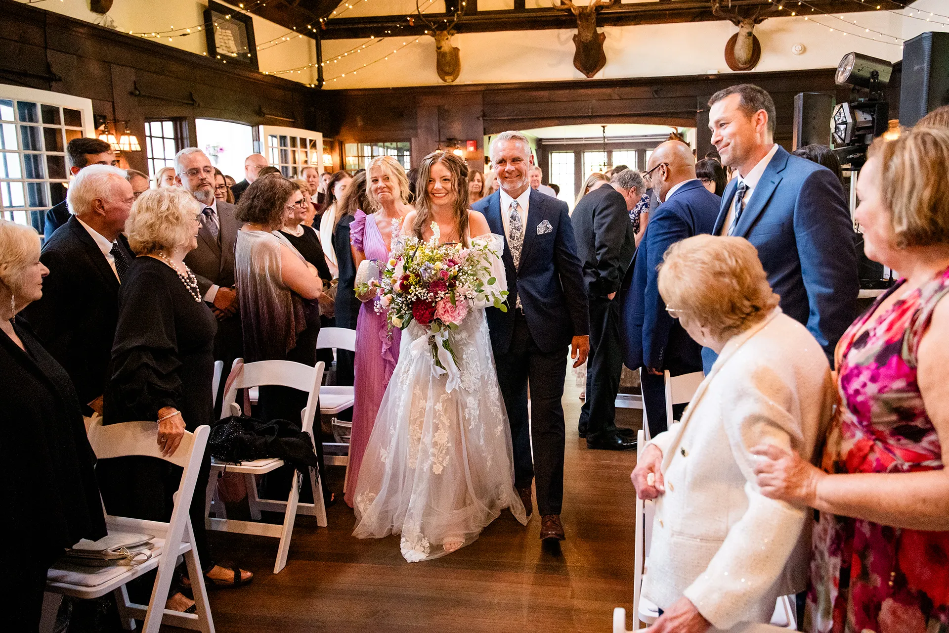 maine wedding photography bethany mike 28 A bride and her parents walk down the aisle during a wedding ceremony at York Harbor Reading Room in York, Maine.