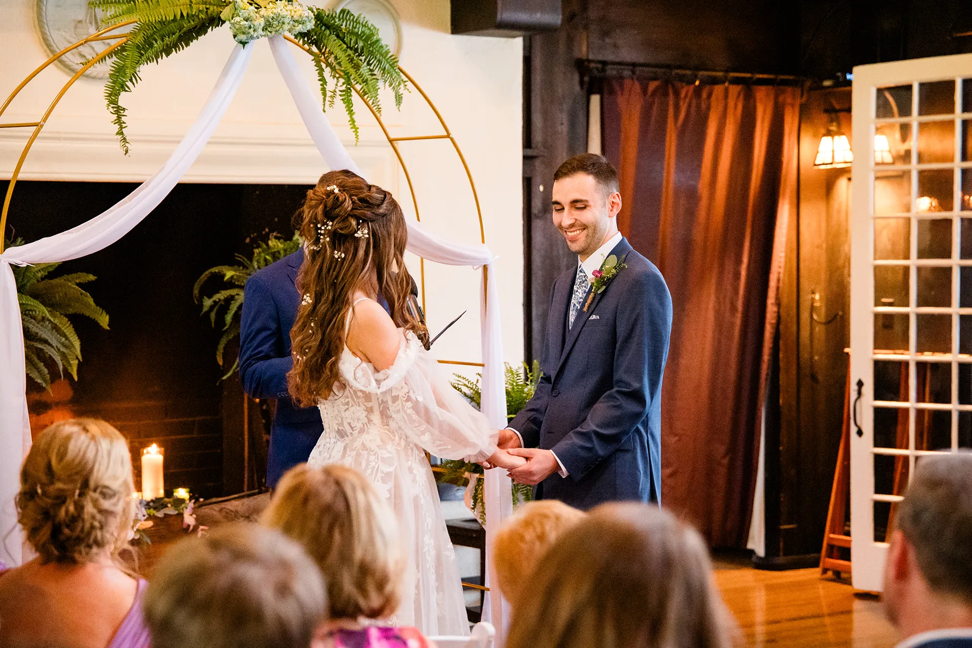 maine wedding photography bethany mike 33 A groom laughs as he hold a bride's hands during a wedding ceremony at York Harbor Reading Room in York, Maine.