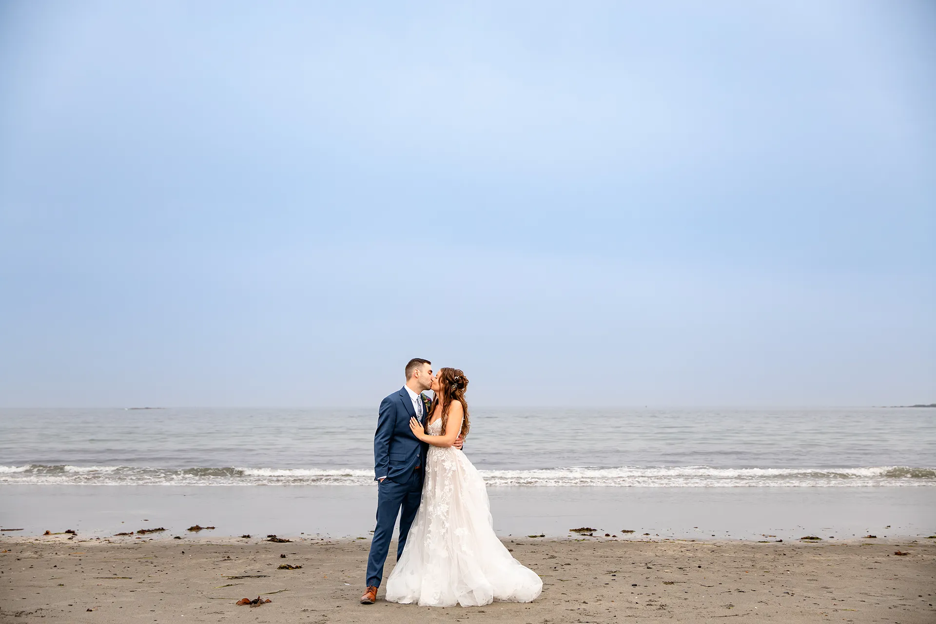 maine wedding photography bethany mike 49 A bride and groom kiss on York Harbor Beach during wedding portraits in York, Maine.