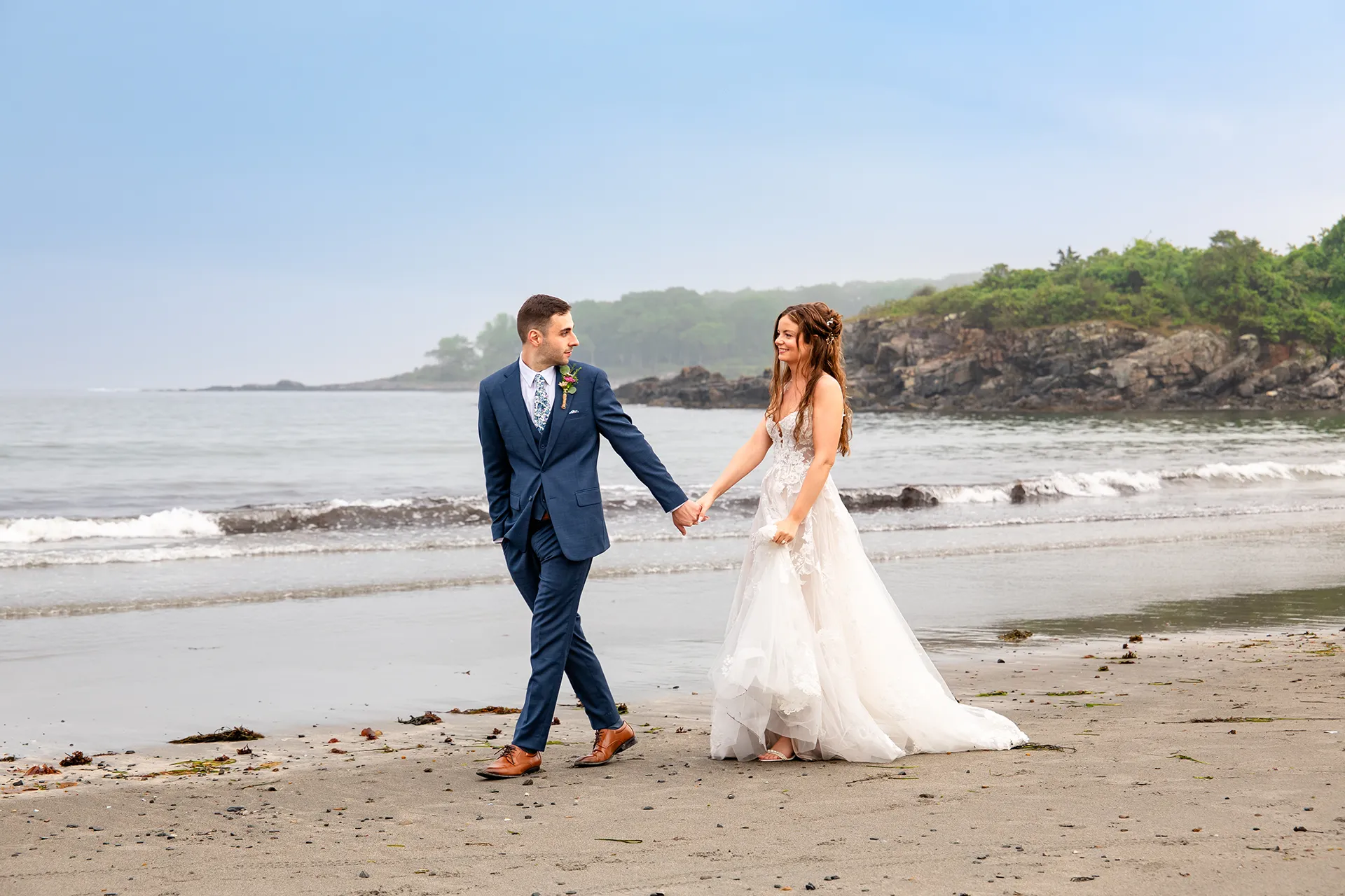maine wedding photography bethany mike 52 A newly married couple hold hands as they walk along York Harbor Beach during wedding portraits in York, Maine.