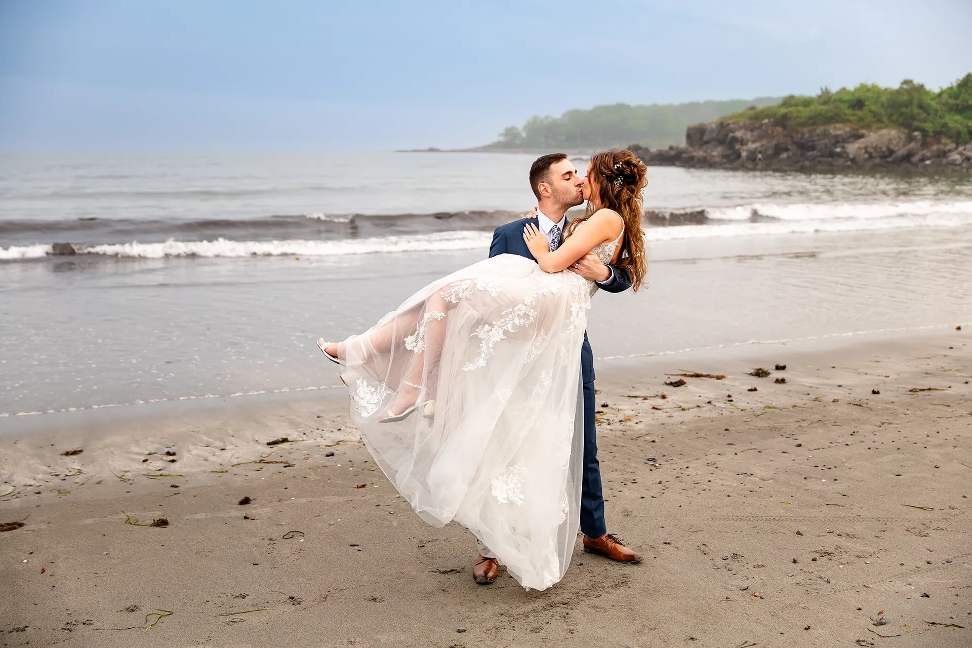 maine wedding photography bethany mike 55 A groom picks up a bride and they kiss during wedding portraits on York Harbor Beach in York, Maine.