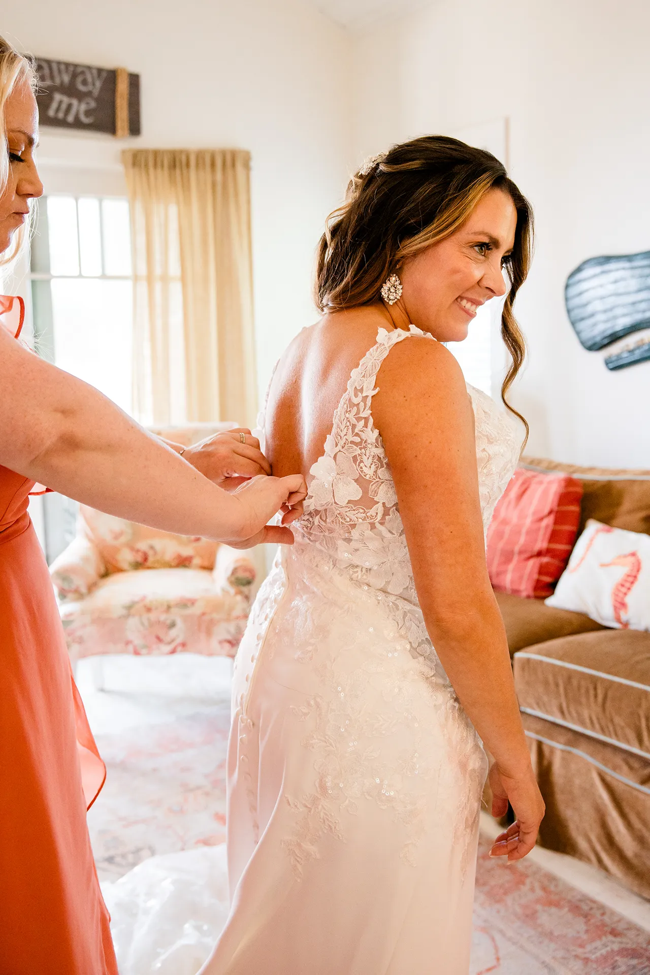 A bride smiles as a bridesmaid helps her get ready for a wedding at the Newagen Seaside Inn in Southport Maine.