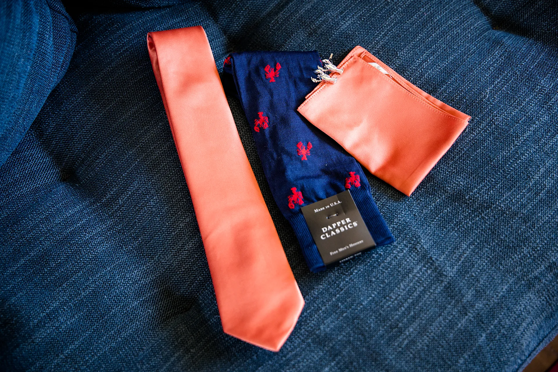 A closeup of a groom's tie, socks, and lobster cufflinks for a wedding at the Newagen Seaside Inn in Southport Maine.