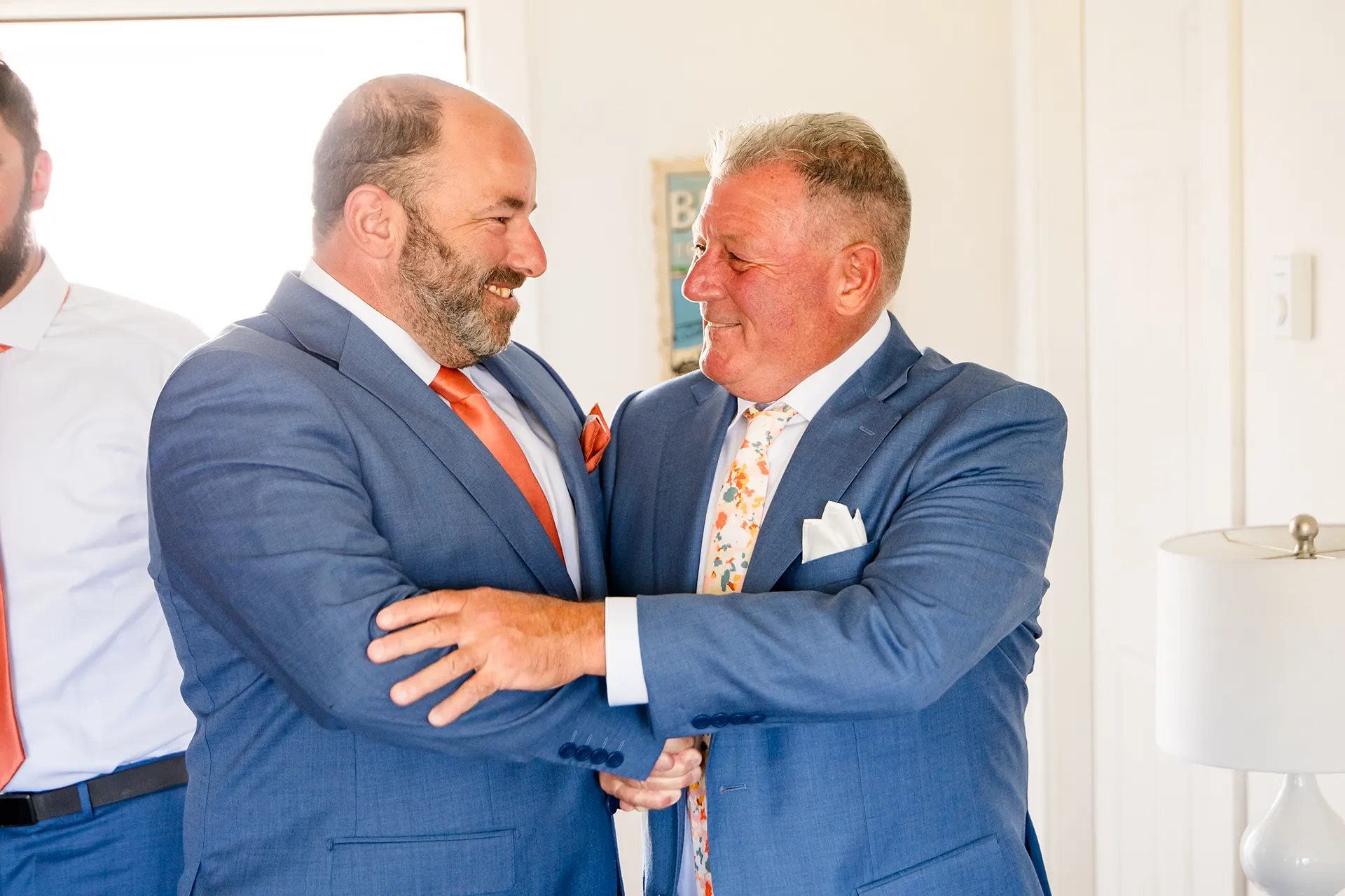 A groom and a bride's dad shake hands and smile as they get ready for a wedding at the Newagen Seaside Inn in Southport Maine.