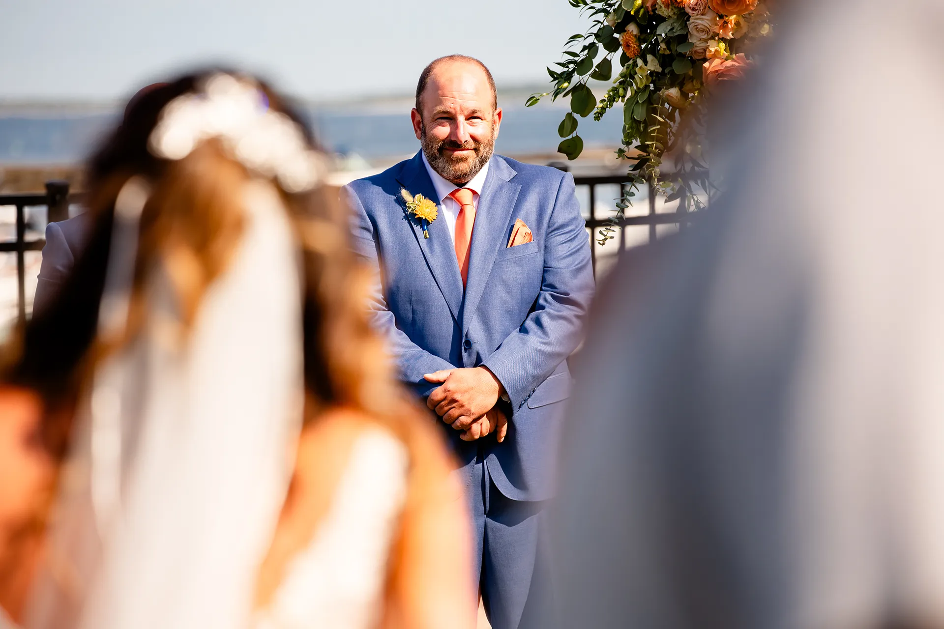 A groom smiles as he watches a bride walk down the aisle during a wedding ceremony at the Newagen Seaside Inn in Southport Maine.