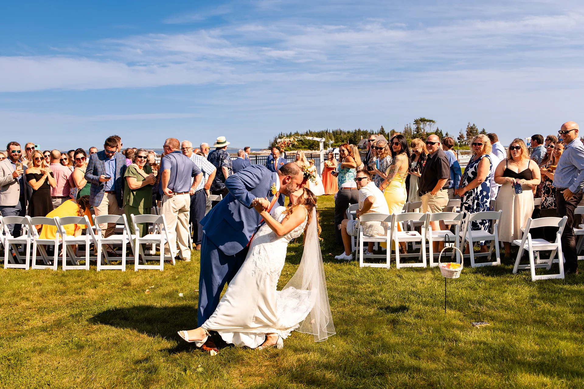 A groom dips a bride and they kiss after walking down the aisle during a wedding ceremony at the Newagen Seaside Inn in Southport Maine.