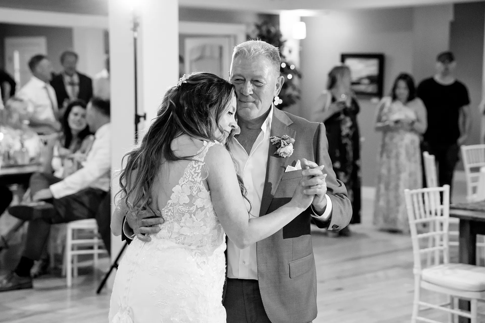A bride rests her head on her dad's chest while they dance at a wedding reception at the Newagen Seaside Inn in Southport Maine.