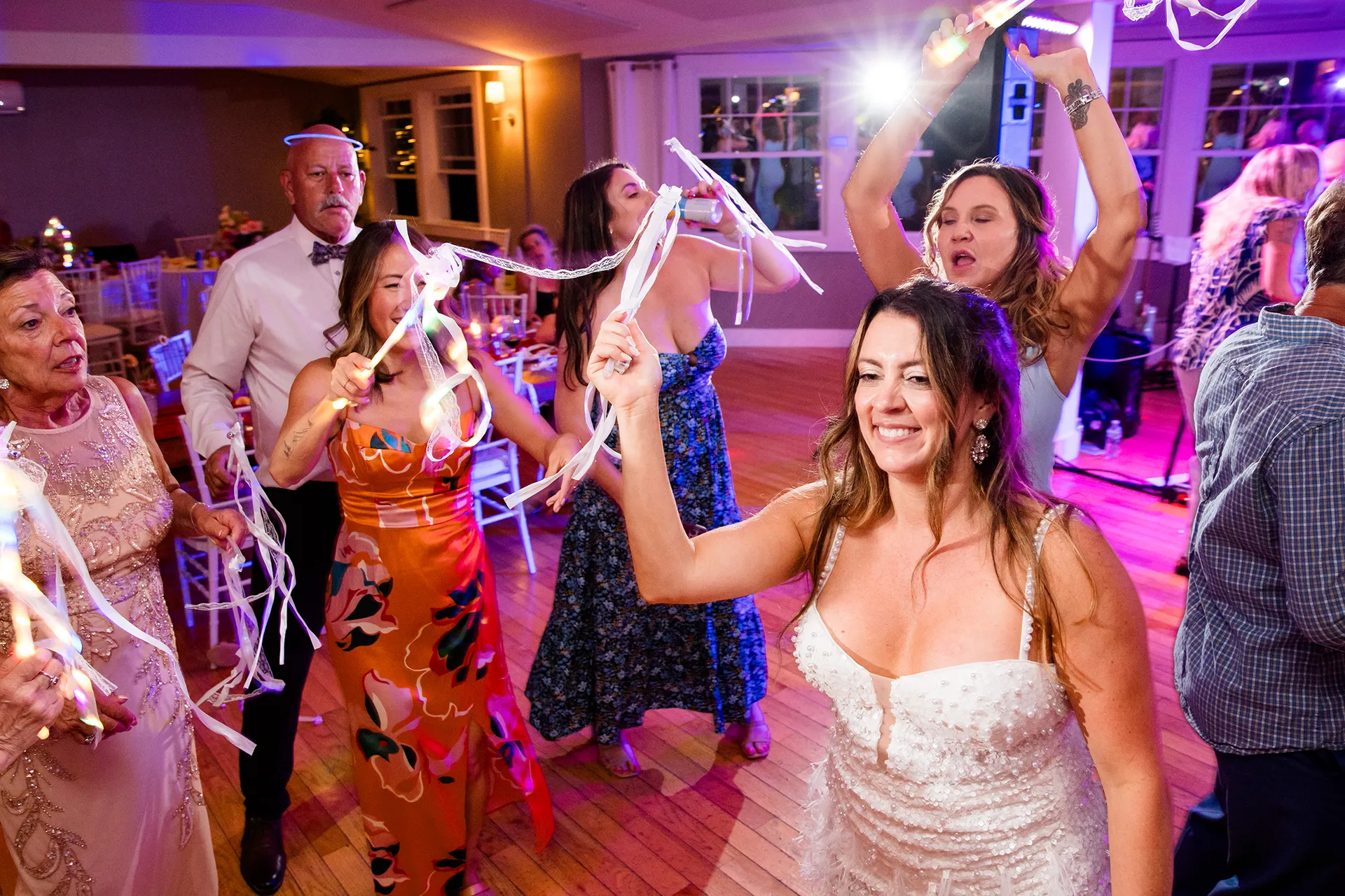 A bride smiles as she dances with her guests during a wedding reception at the Newagen Seaside Inn in Southport Maine.