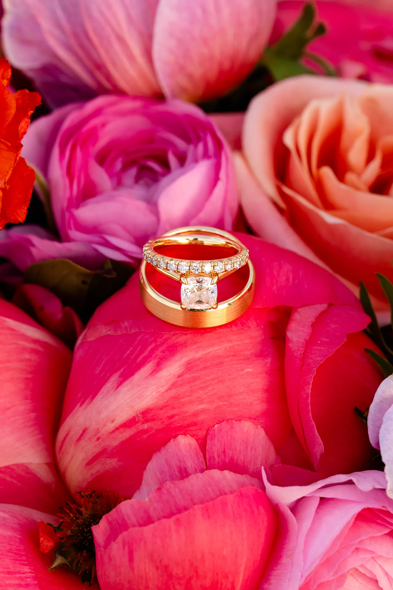 maine wedding photography caroline max 22 A closeup of gold wedding rings sitting on a pink flower at the Bar Harbor Inn and Spa in Bar Harbor, Maine.