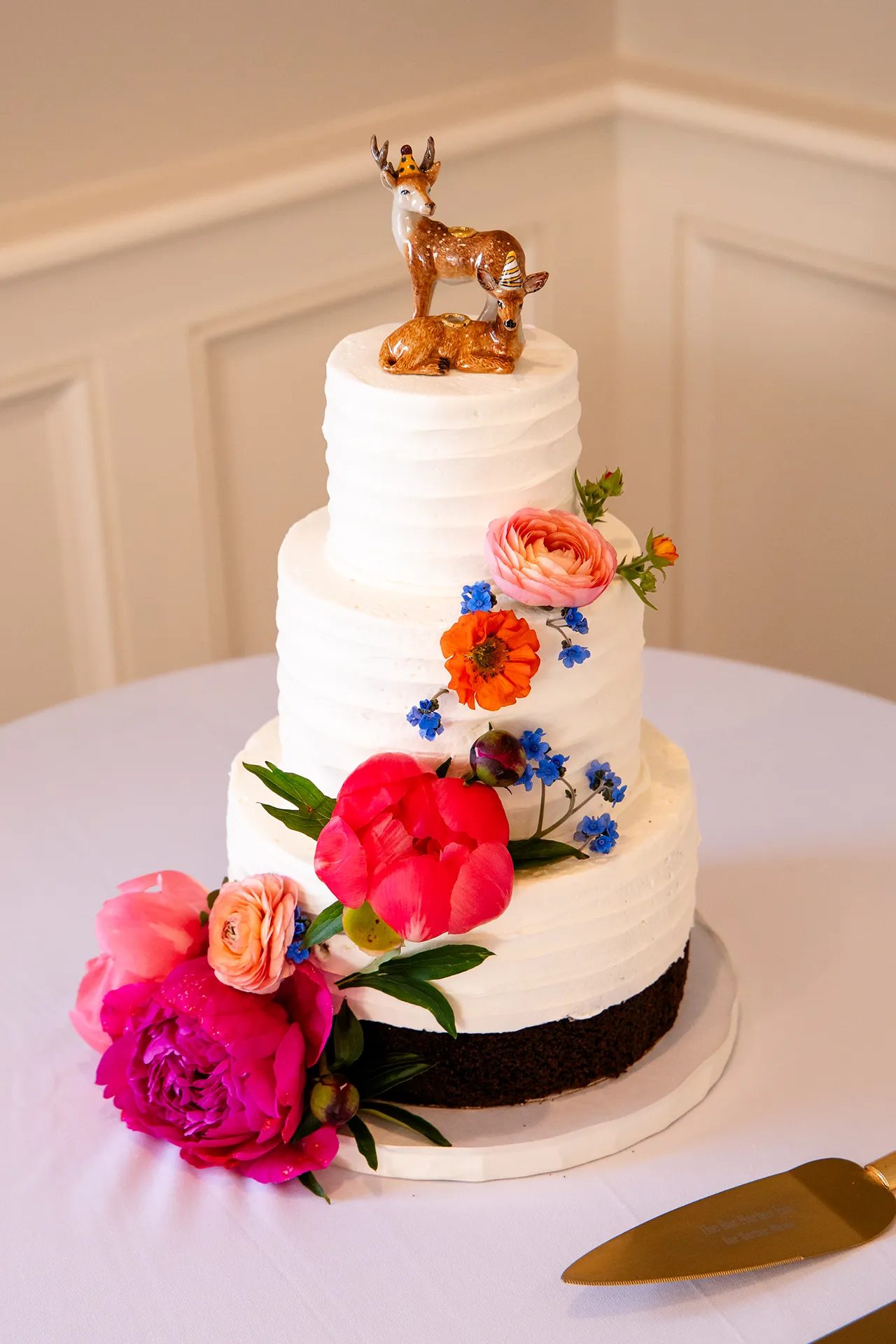 maine wedding photography caroline max 27 A white wedding cake with colorful flowers in the Porcupine Room at the Bar Harbor Inn and Spa in Bar Harbor, Maine.