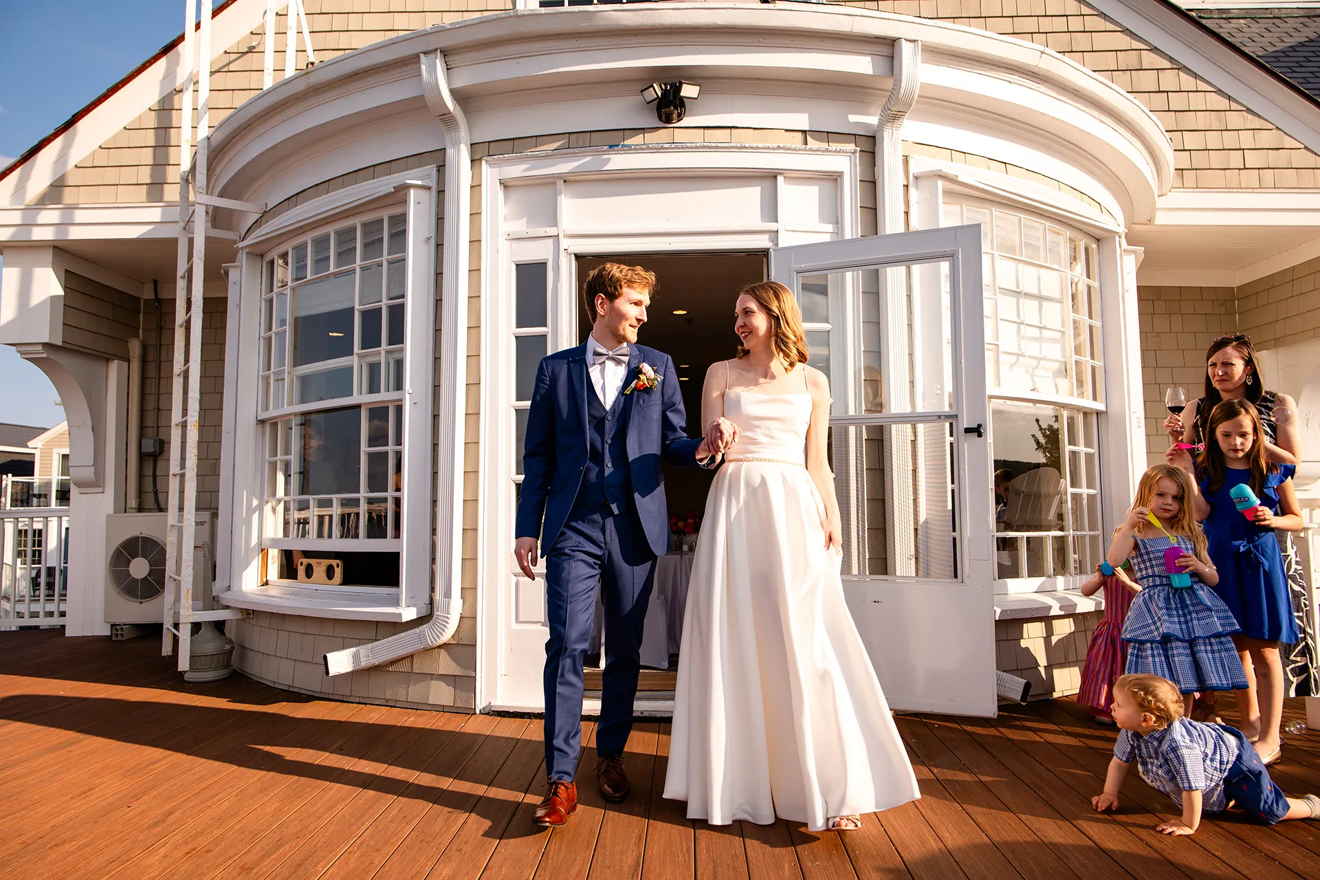 maine wedding photography caroline max 28 A bride and groom hold hands as they enter their wedding reception in the Porcupine Room at the Bar Harbor Inn and Spa in Bar Harbor, Maine.