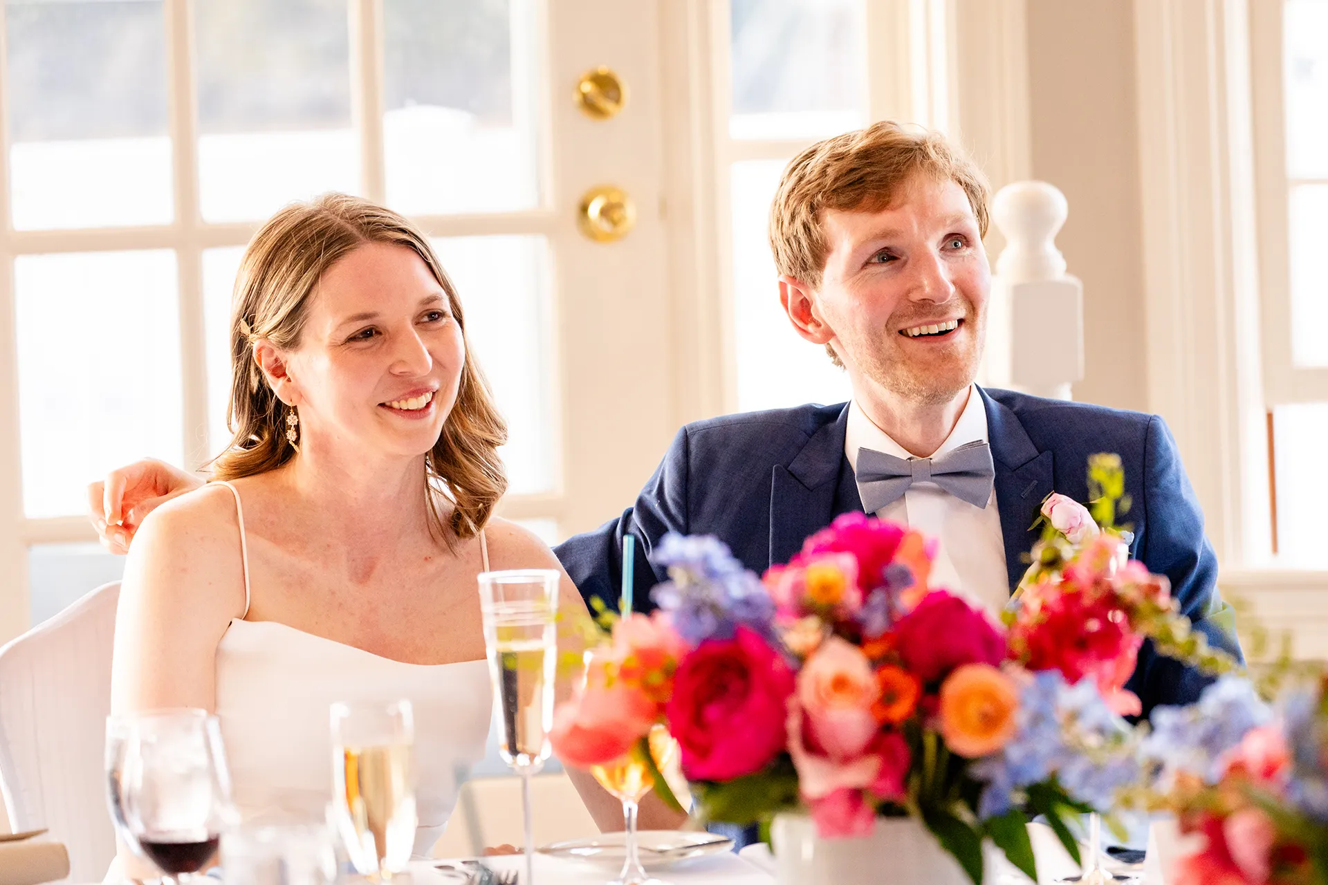 maine wedding photography caroline max 30 A bride and groom smile as they listen to a toast during their wedding reception at the Bar Harbor Inn and Spa in Bar Harbor, Maine.