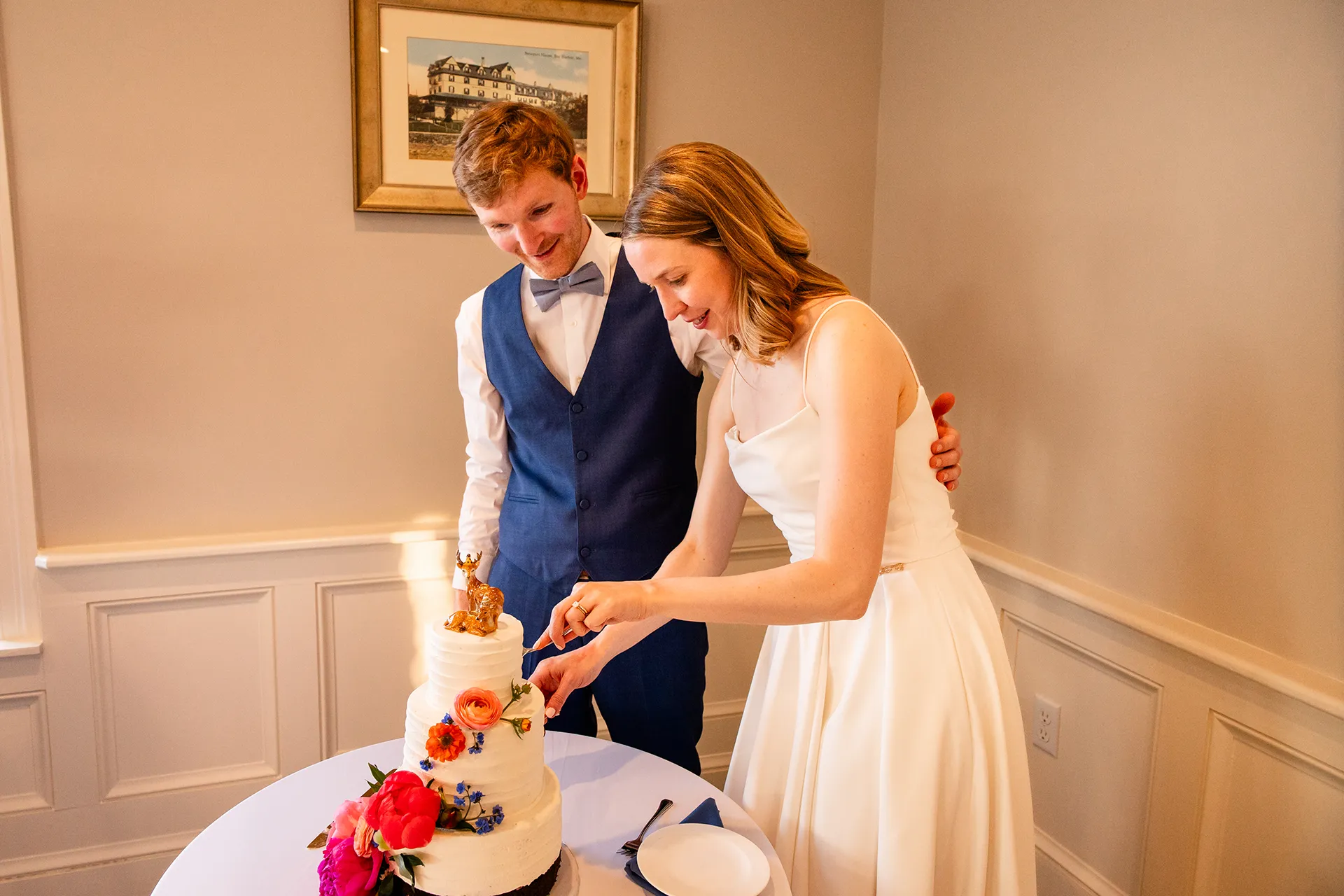 maine wedding photography caroline max 32 A bride and groom cut a wedding cake in the Porcupine Room at the Bar Harbor Inn and Spa in Bar Harbor, Maine.