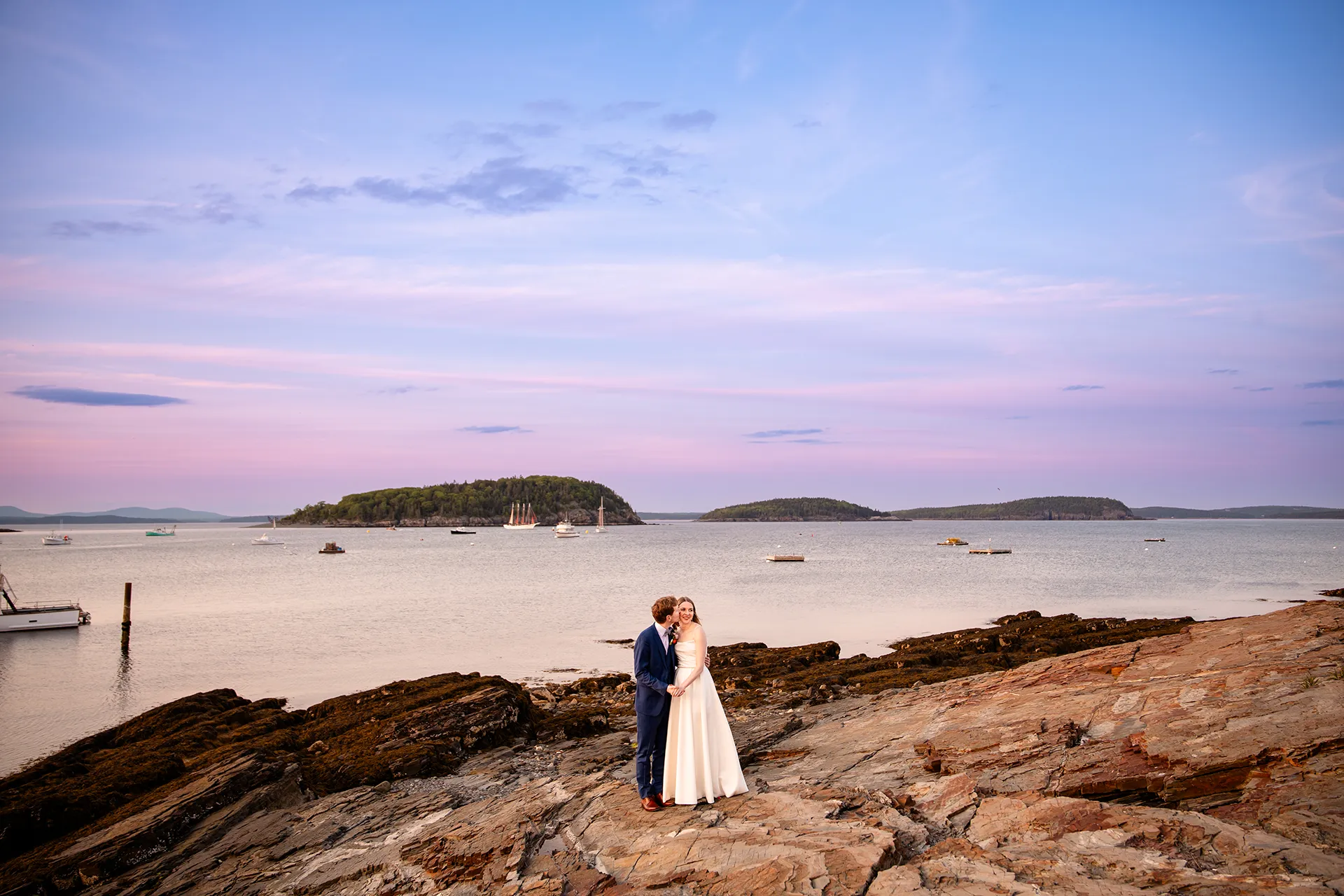 maine wedding photography caroline max 38 A bride smiles as a groom kisses her on the cheek during wedding portraits at the Bar Harbor Inn and Spa in Bar Harbor, Maine.