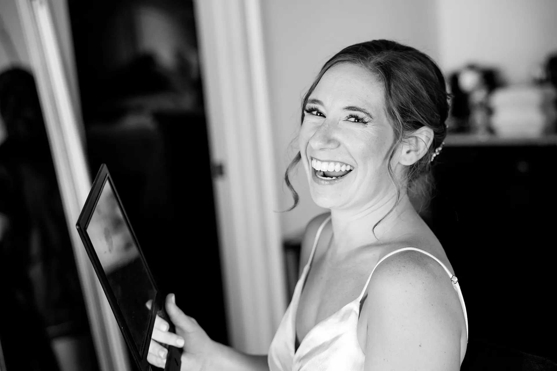 A brides laughs after looking at her makeup for a wedding at the Atlantic Oceanside Hotel & Event Center in Bar Harbor, Maine.