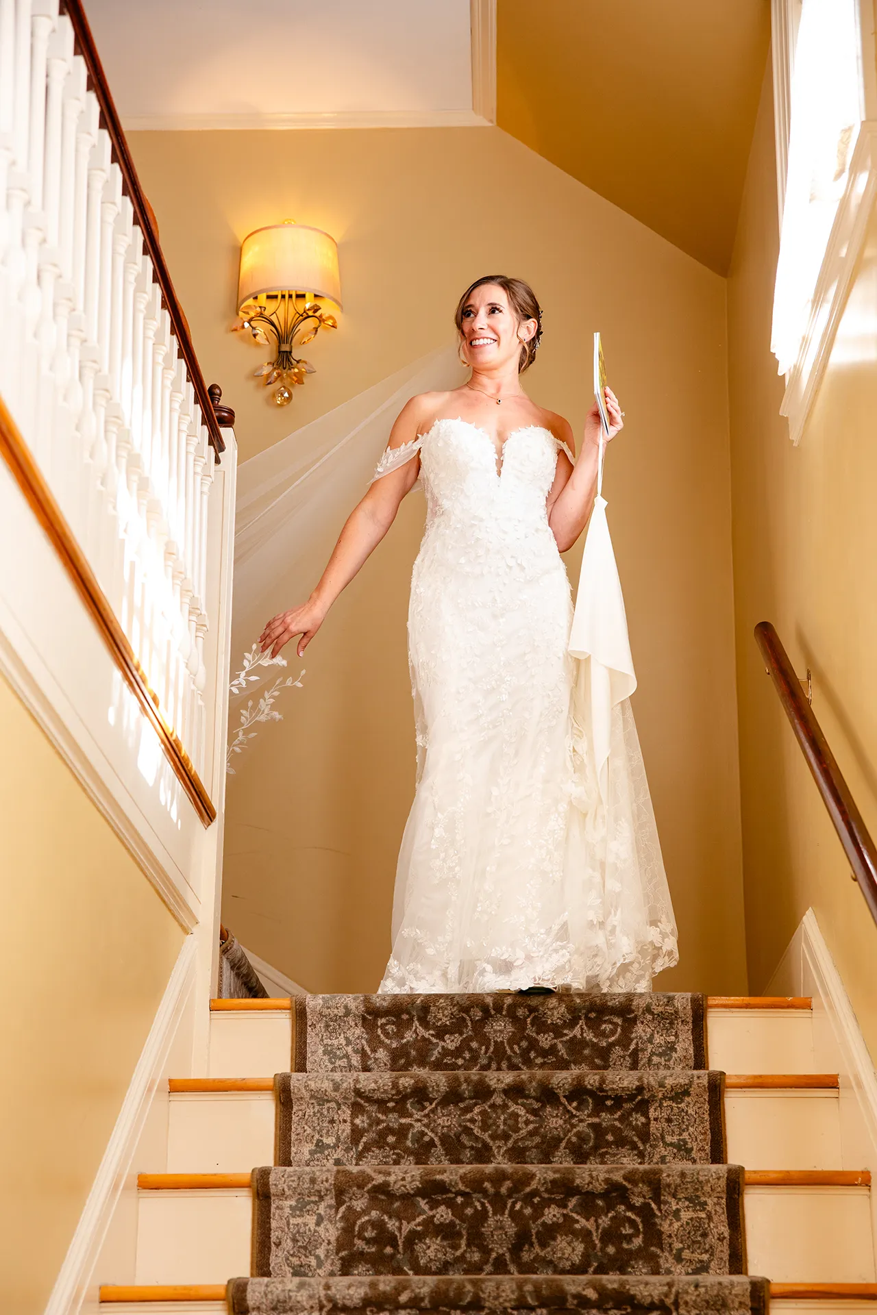 A brides stands on the stairs at the Willows on the property of the Atlantic Oceanside Hotel & Event Center in Bar Harbor, Maine.