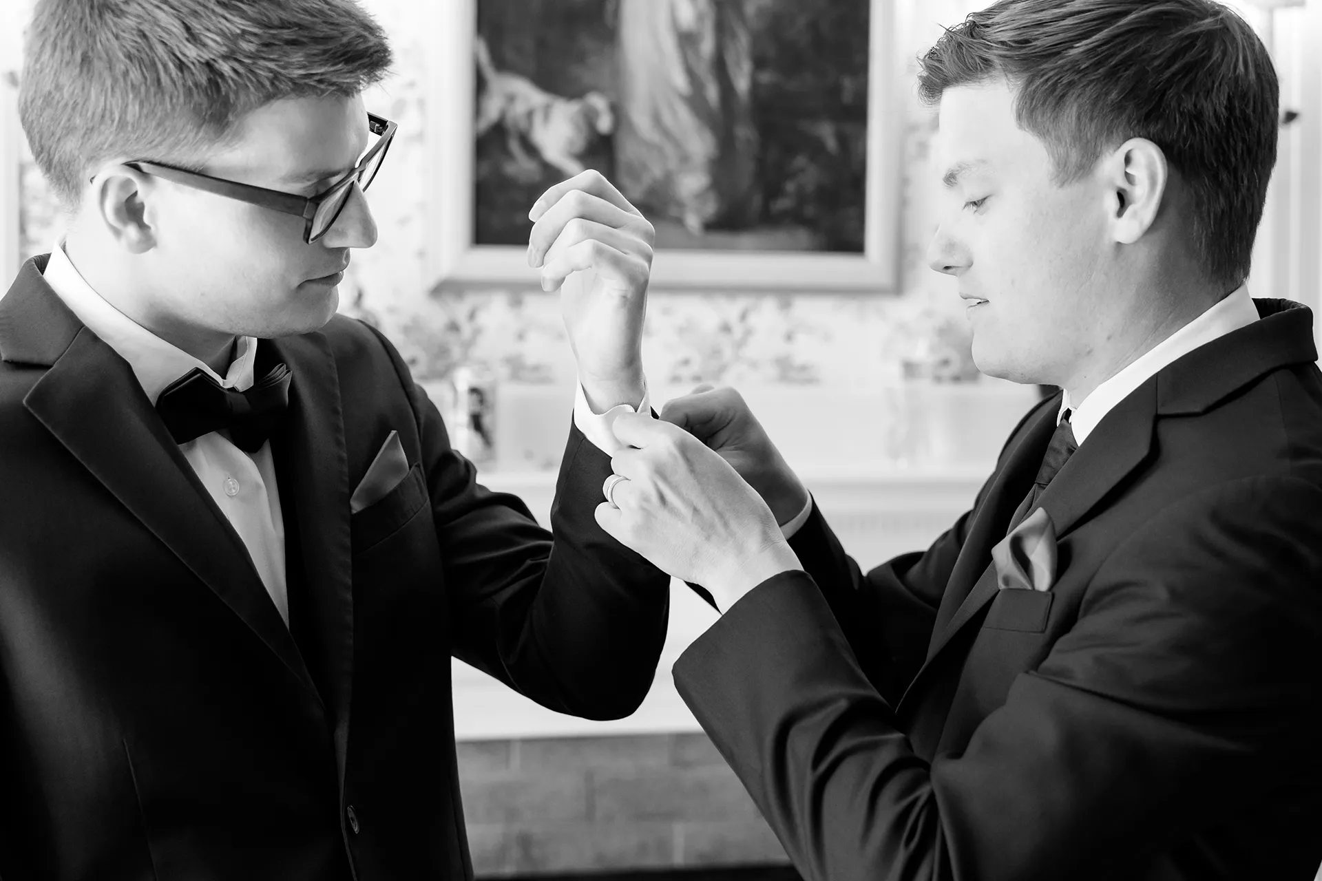 A groomsman helps a groom put on his cufflinks as he gets ready for a wedding at the Atlantic Oceanside Hotel & Event Center in Bar Harbor, Maine.