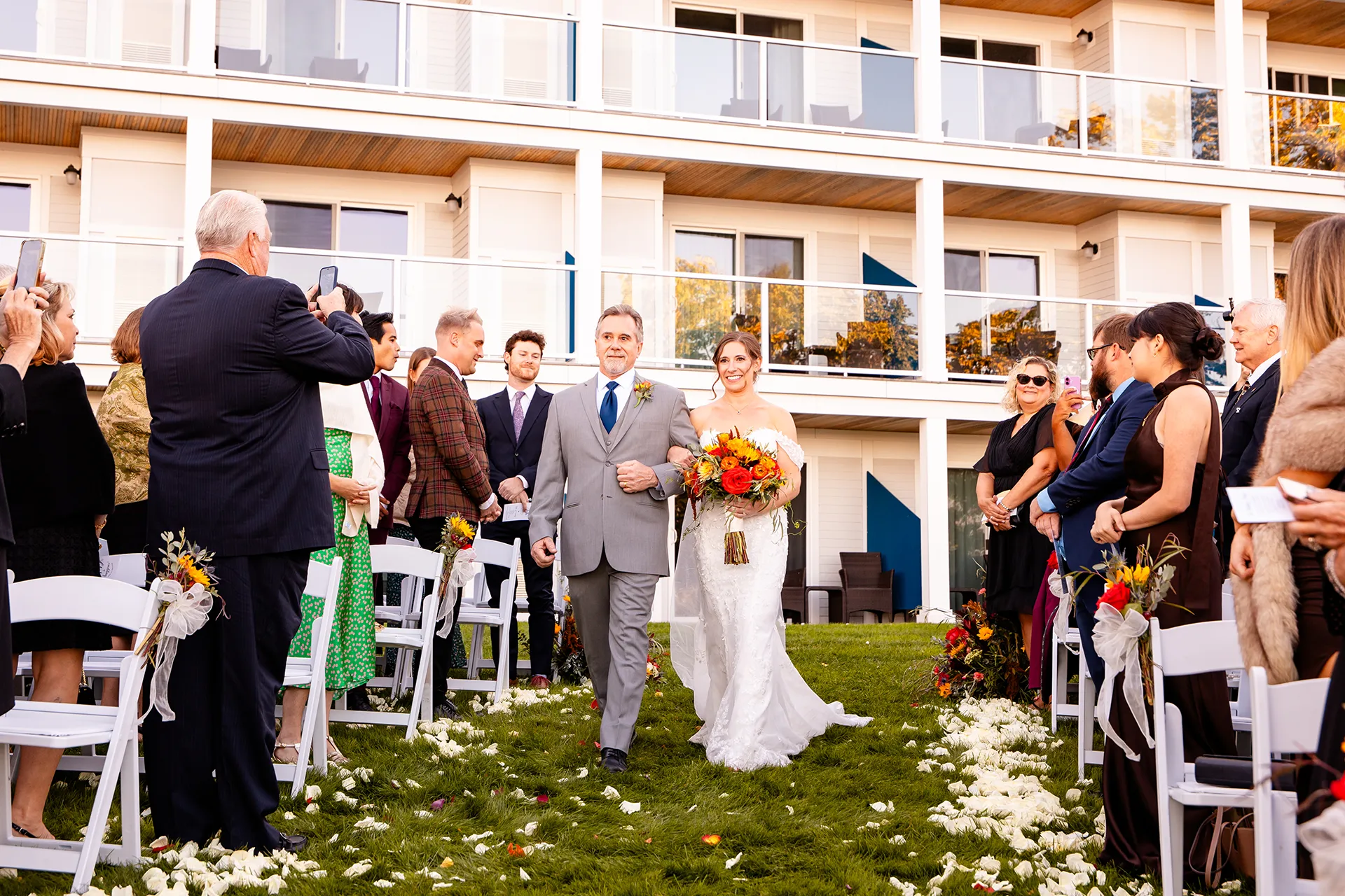A bride and her dad walk down the aisle during a wedding ceremony at the Atlantic Oceanside Hotel & Event Center in Bar Harbor, Maine.